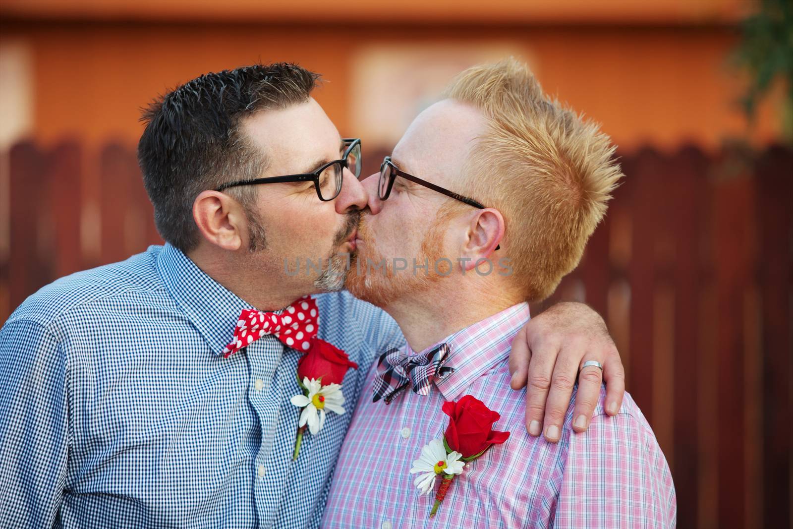 Pair of happily married gay men kissing outdoors