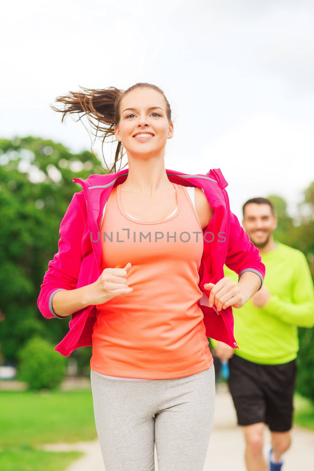 smiling couple running outdoors by dolgachov