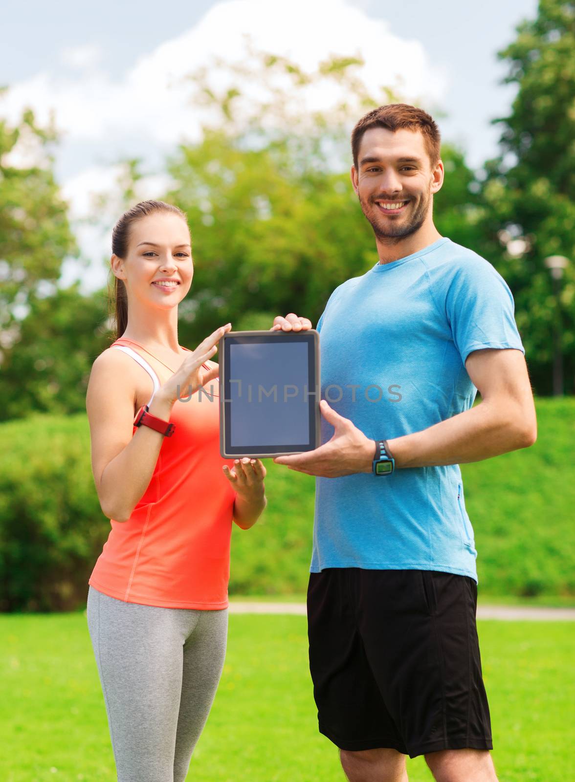 fitness, sport, friendship, technology and lifestyle concept - smiling couple with tablet pc computer outdoors