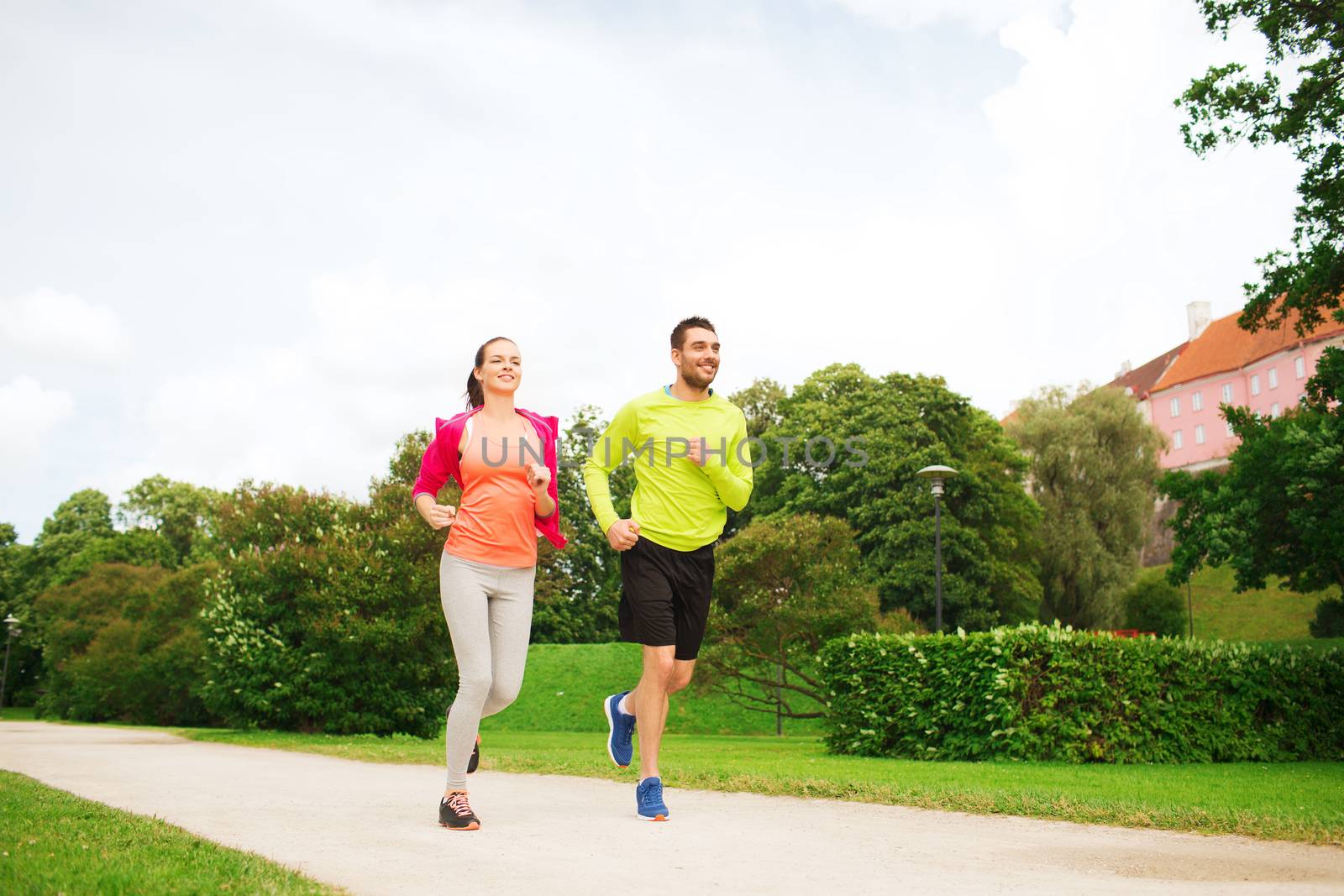 smiling couple running outdoors by dolgachov