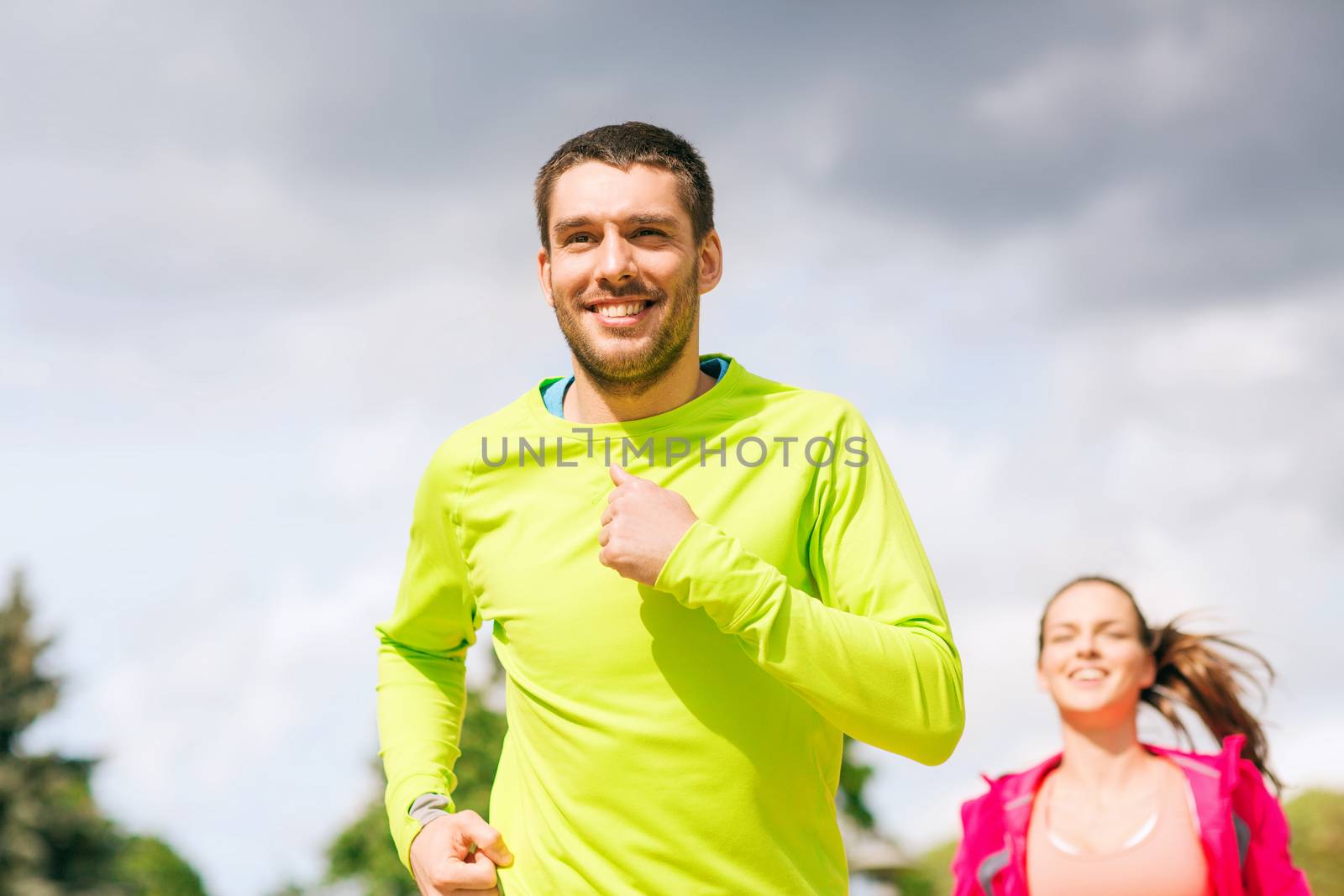 smiling couple running outdoors by dolgachov