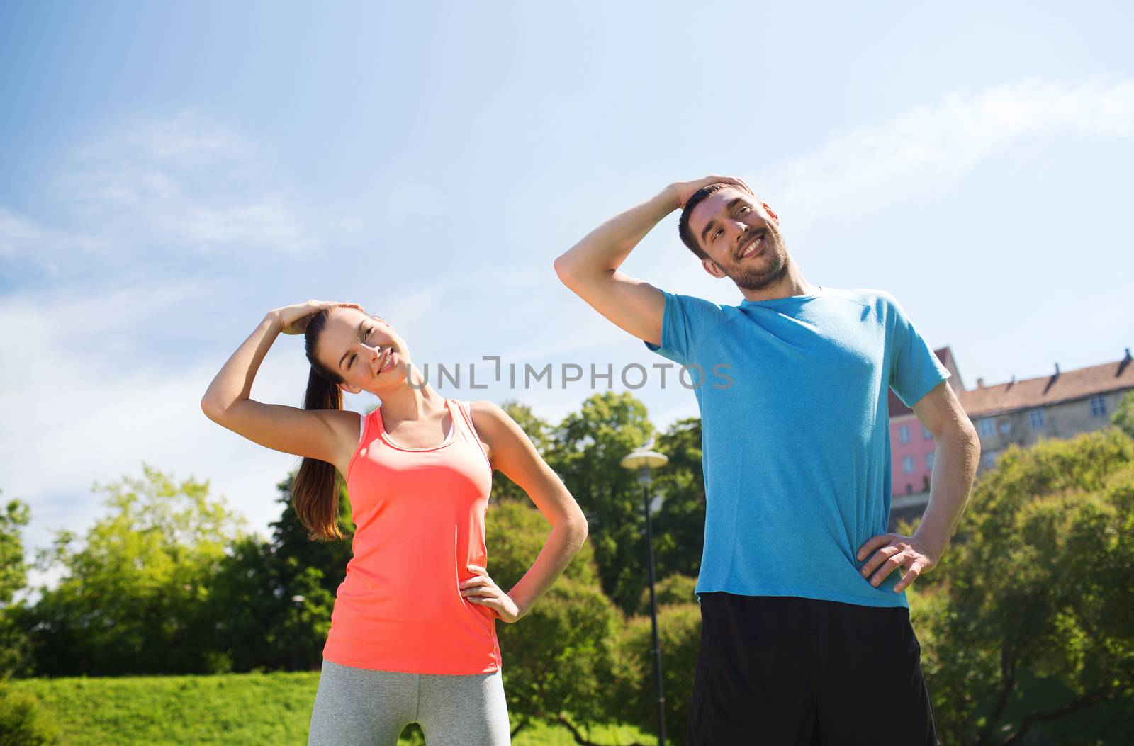 smiling couple stretching outdoors by dolgachov