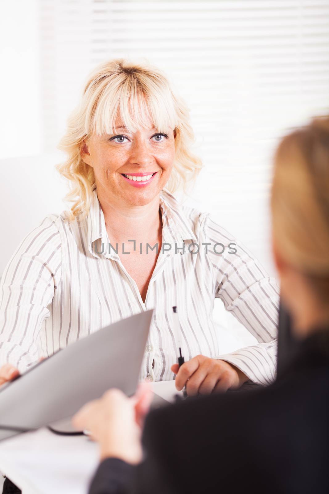 Friendly business women conducting deal in office 