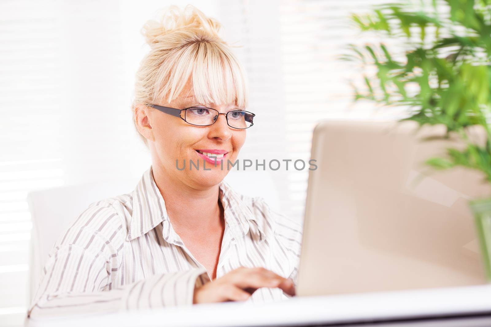 Beautiful mature Business woman working at laptop in the office.