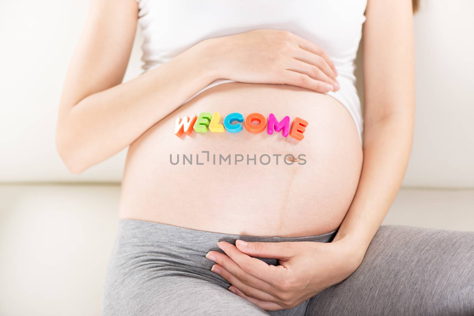 Welcome letters written on a pregnant belly.