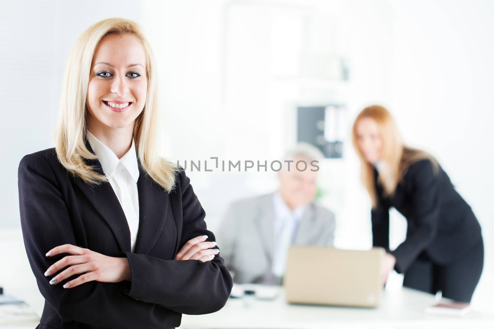 Beautiful young businesswoman with Crossed Arms in the office. Looking at camera. Selective Focus.