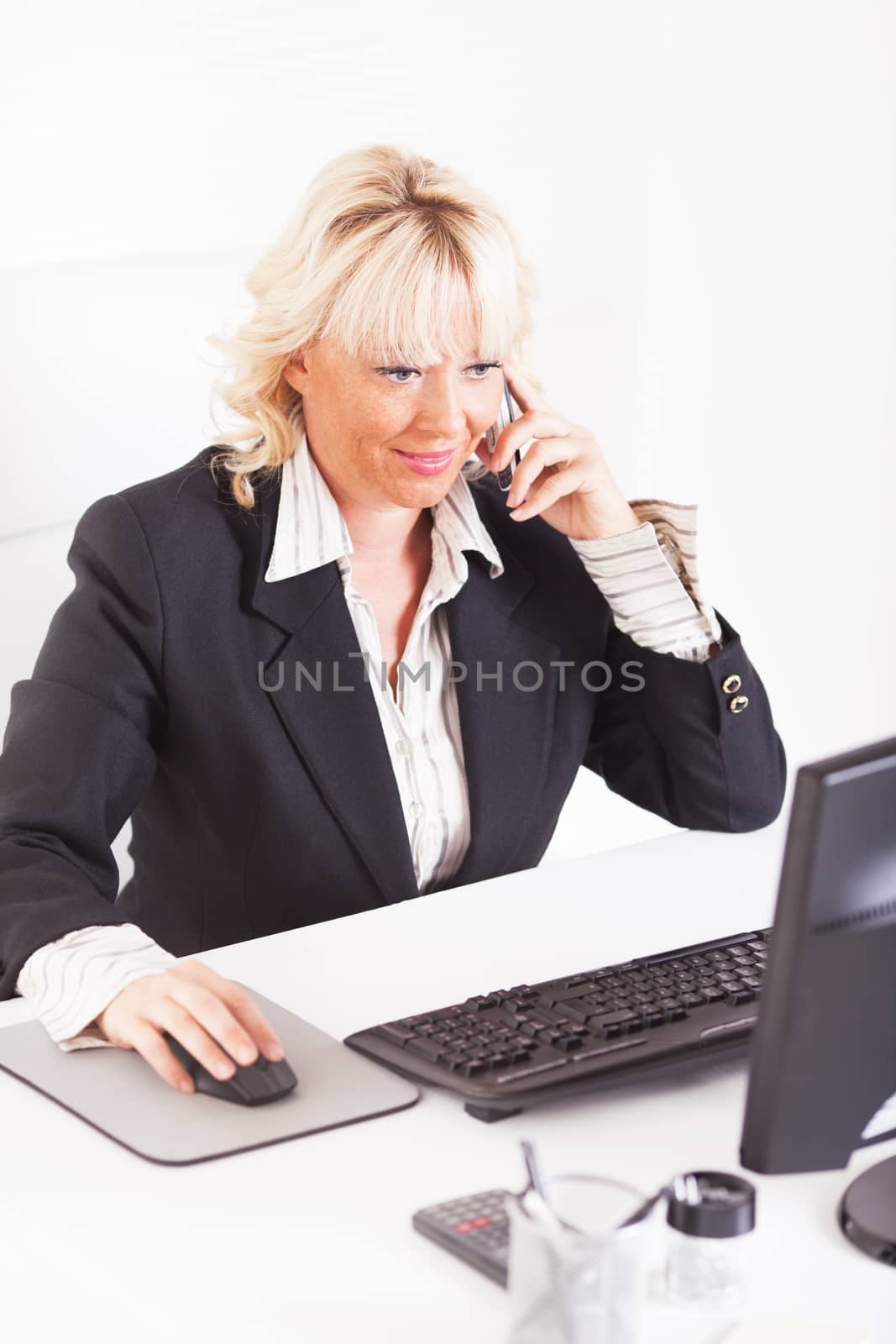 Beautiful mature Business woman talking on mobile phone at workplace