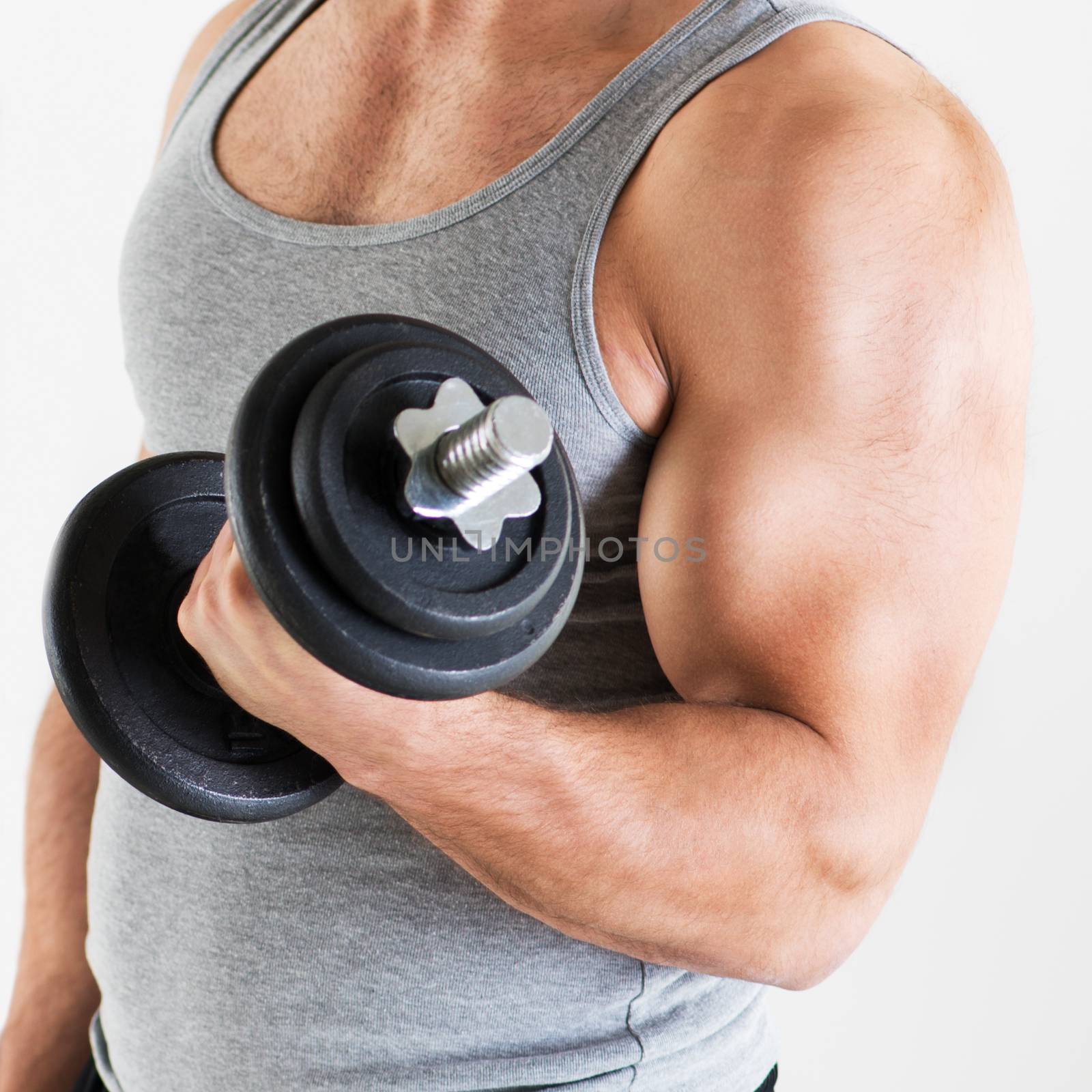 Young muscular man lifting the weights with biceps exercise. Close-up.