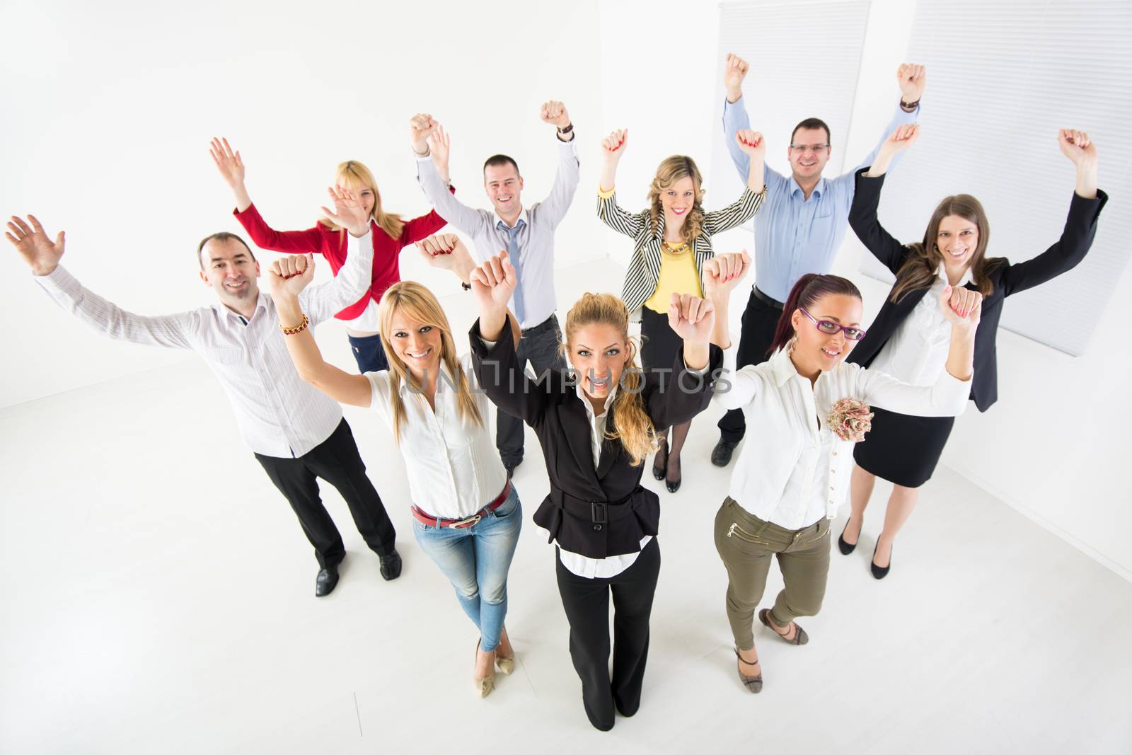 Group of a happy Business People standing together with raised arms.