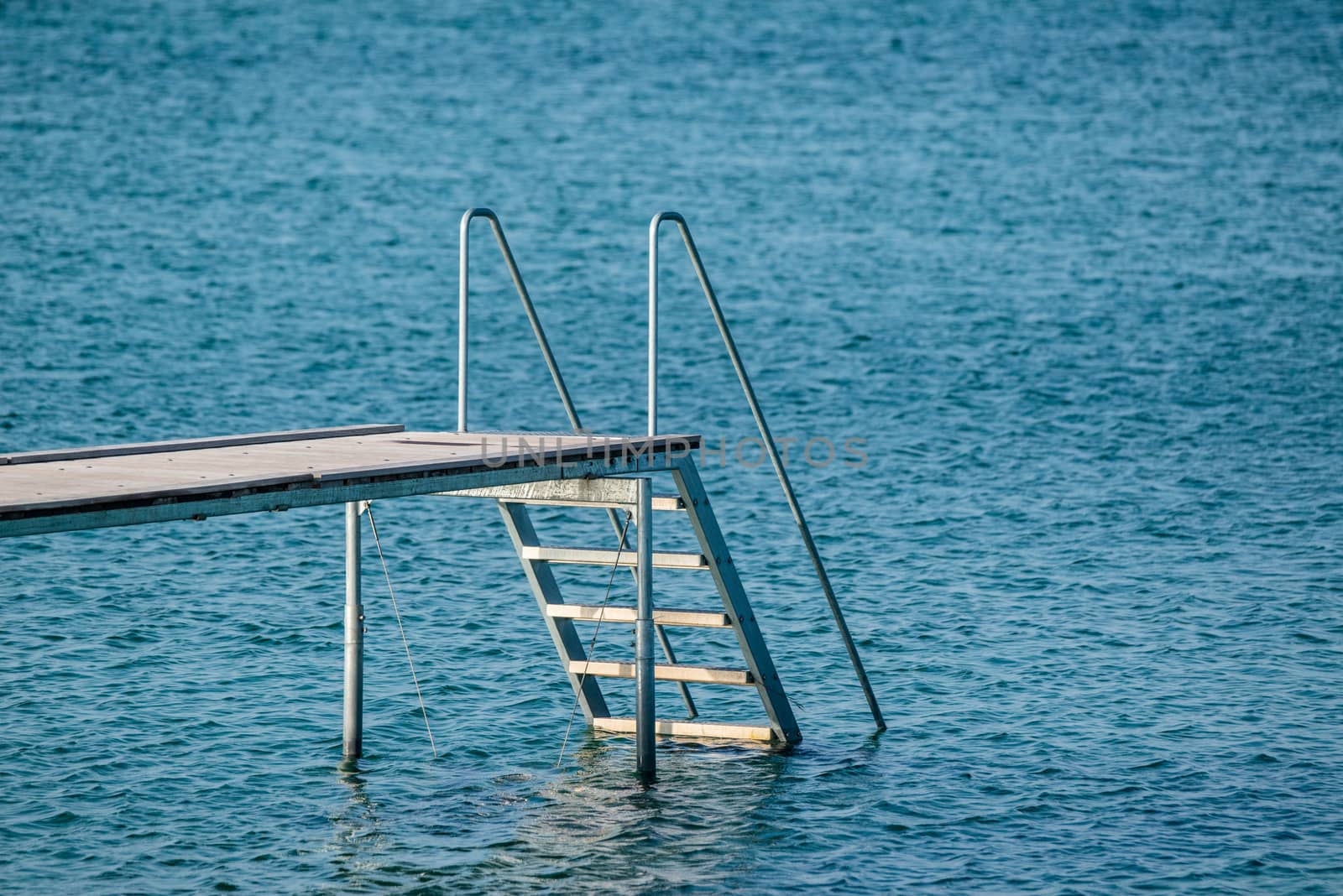Jetty with a ladder at a blue ocean