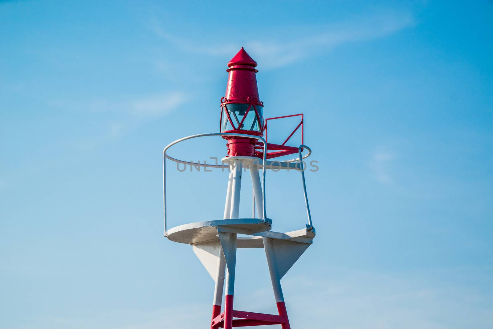 Small lighthouse on blue sky in daylight
