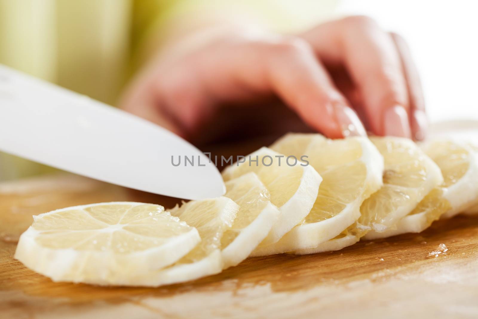 Female hands Cutting lemon in a kitchen. Close-up. Selective Focus.