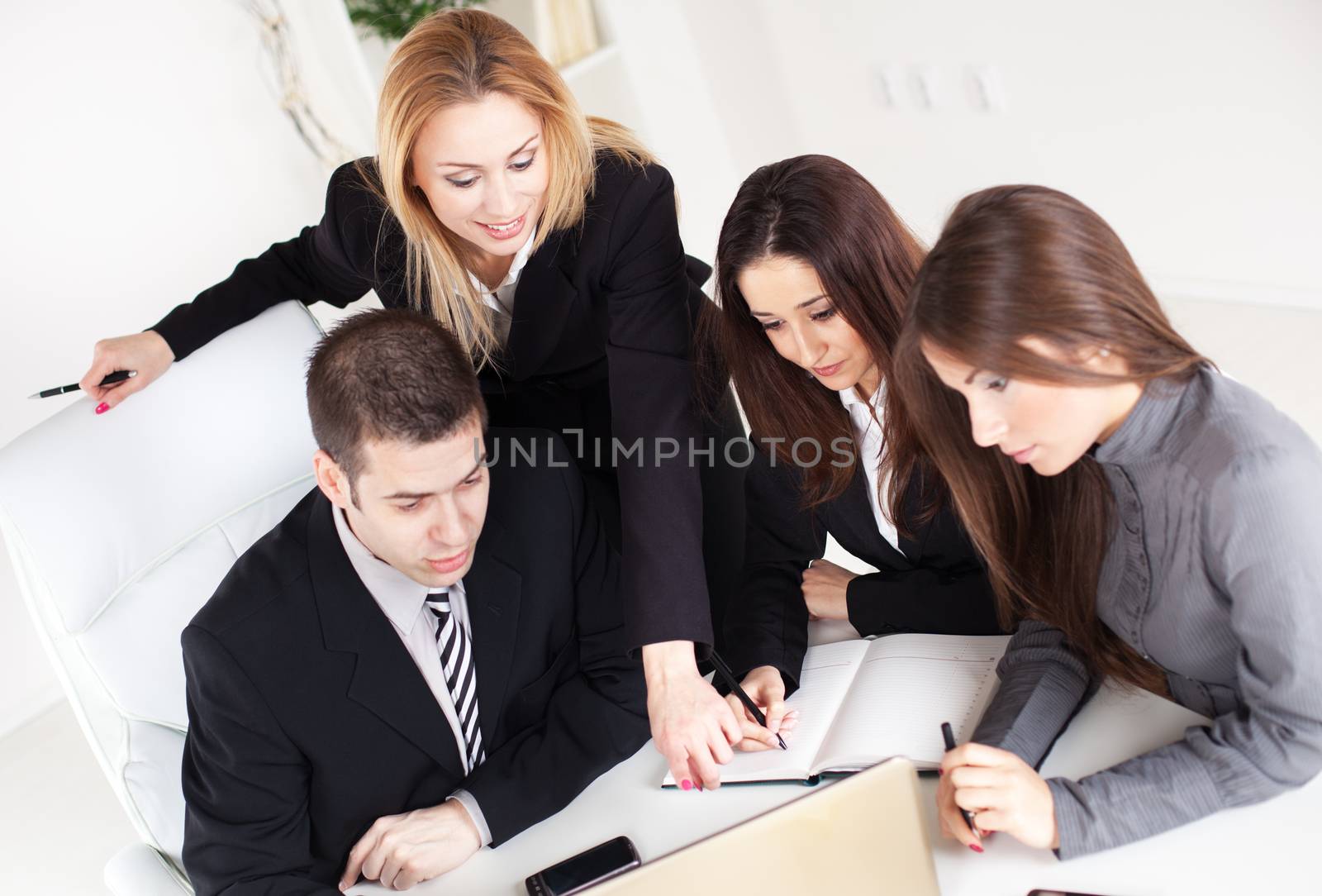 Happy Business woman showing her colleagues project at laptop in the office.