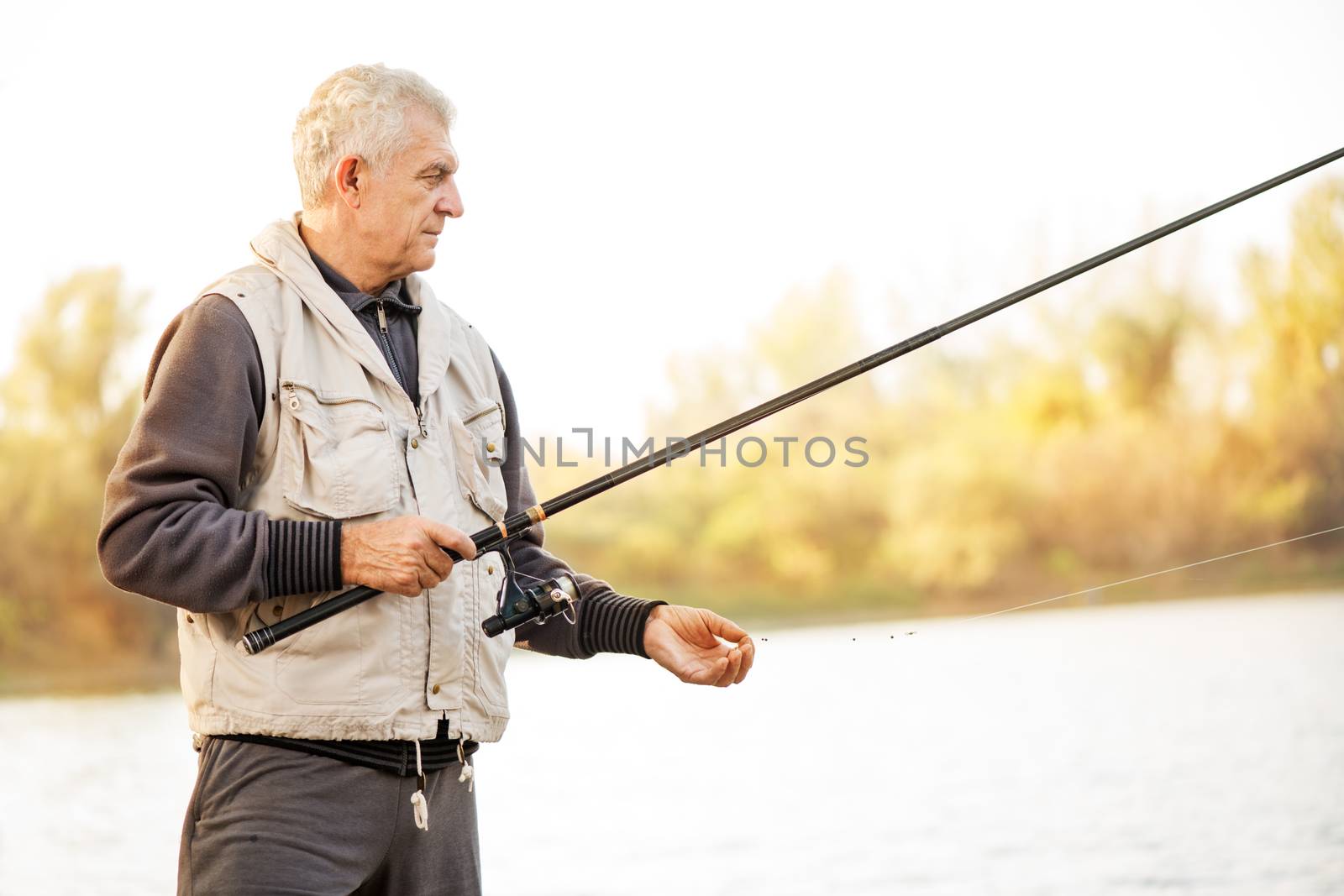 Senior men fishing by the lake.