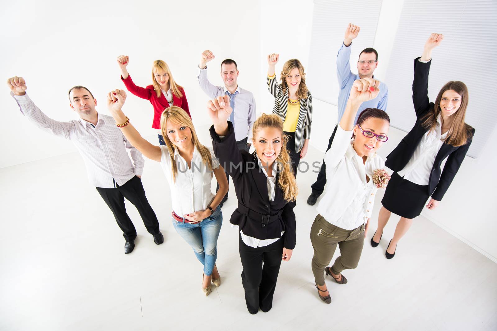 Group of a happy Business People standing together with raised arms in a fist.