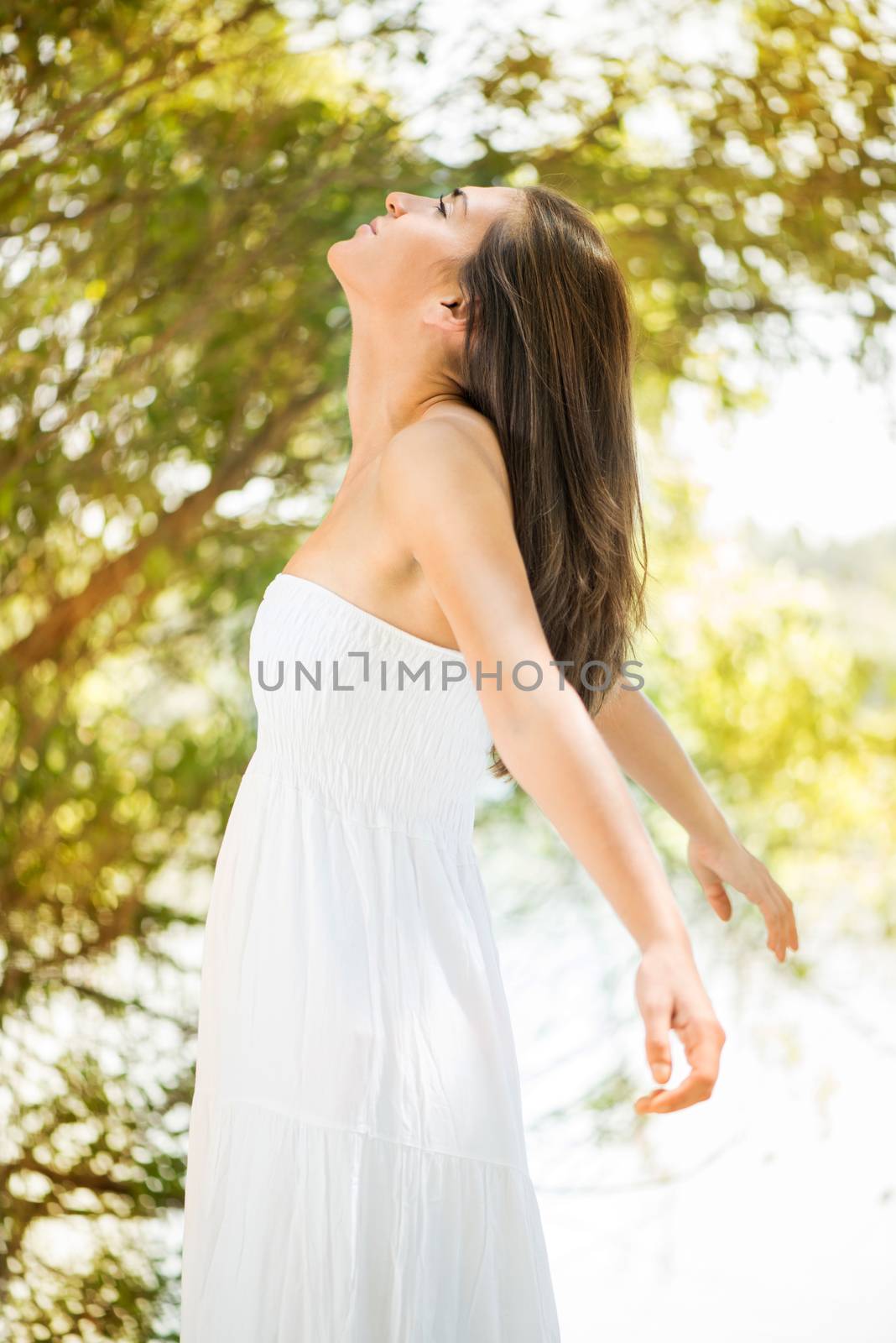 Young beautiful woman with arms outstretched enjoying in the nature.