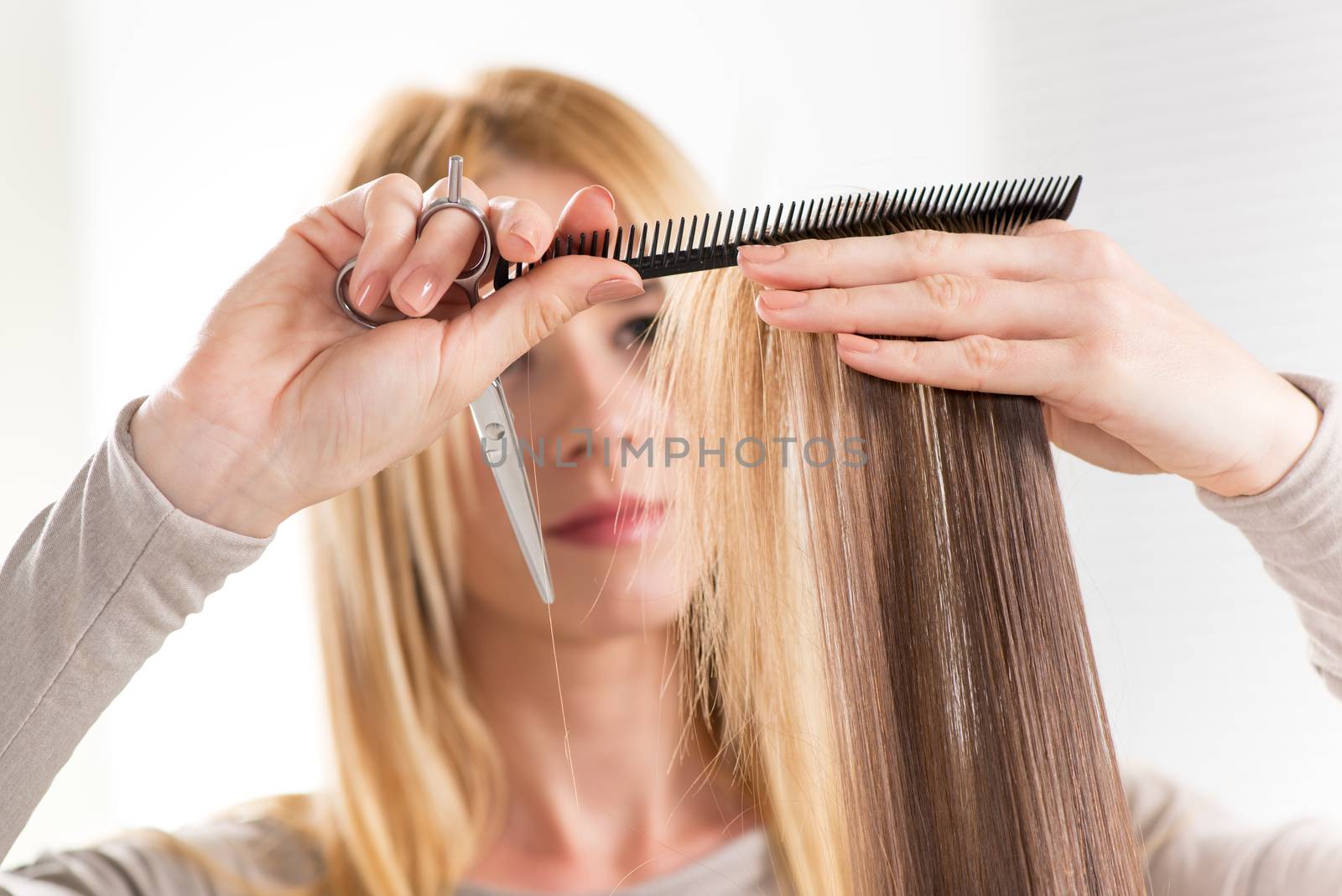 Hairdresser cut hair of a woman.