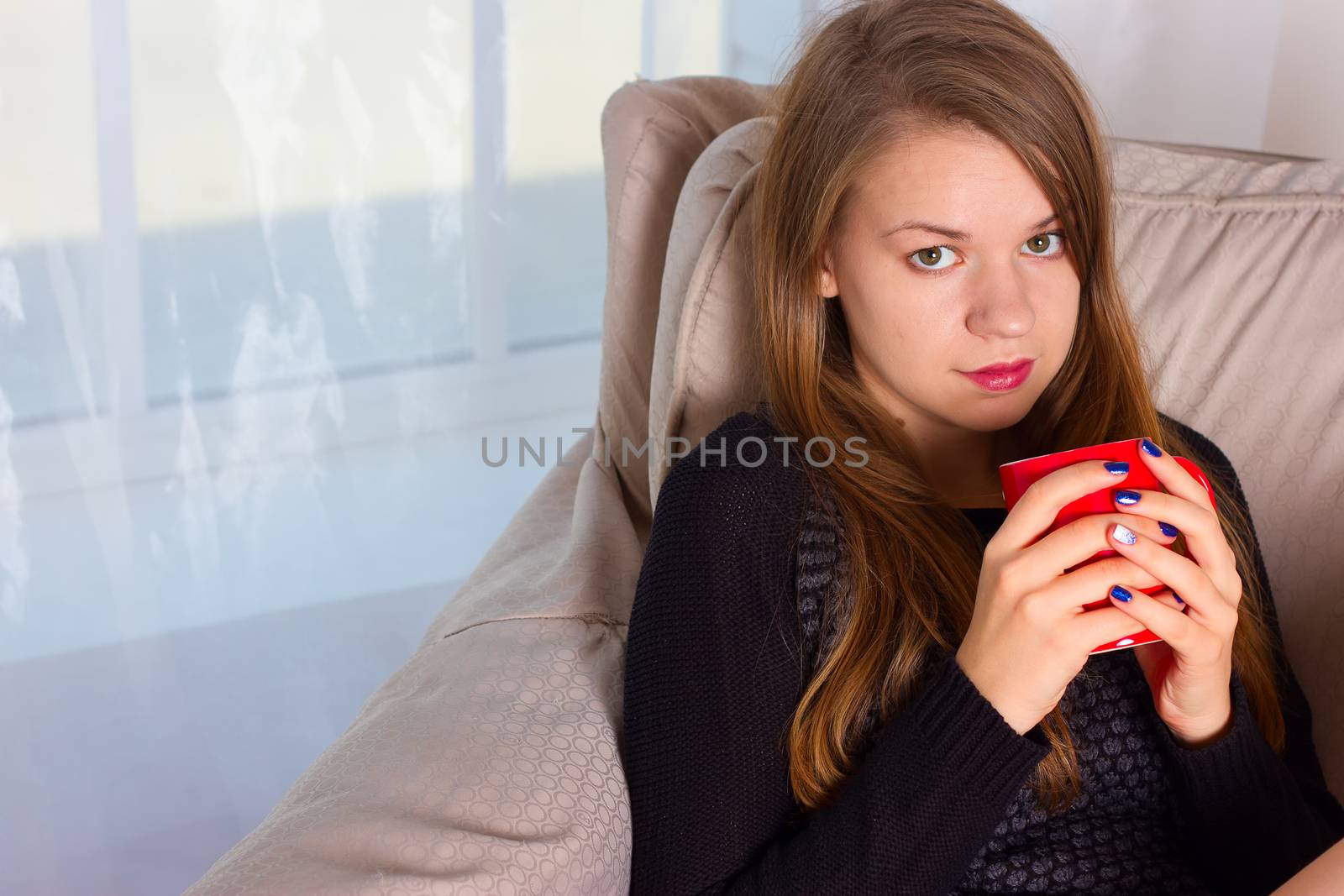 beautiful woman drinking coffee in the morning sitting by the window
