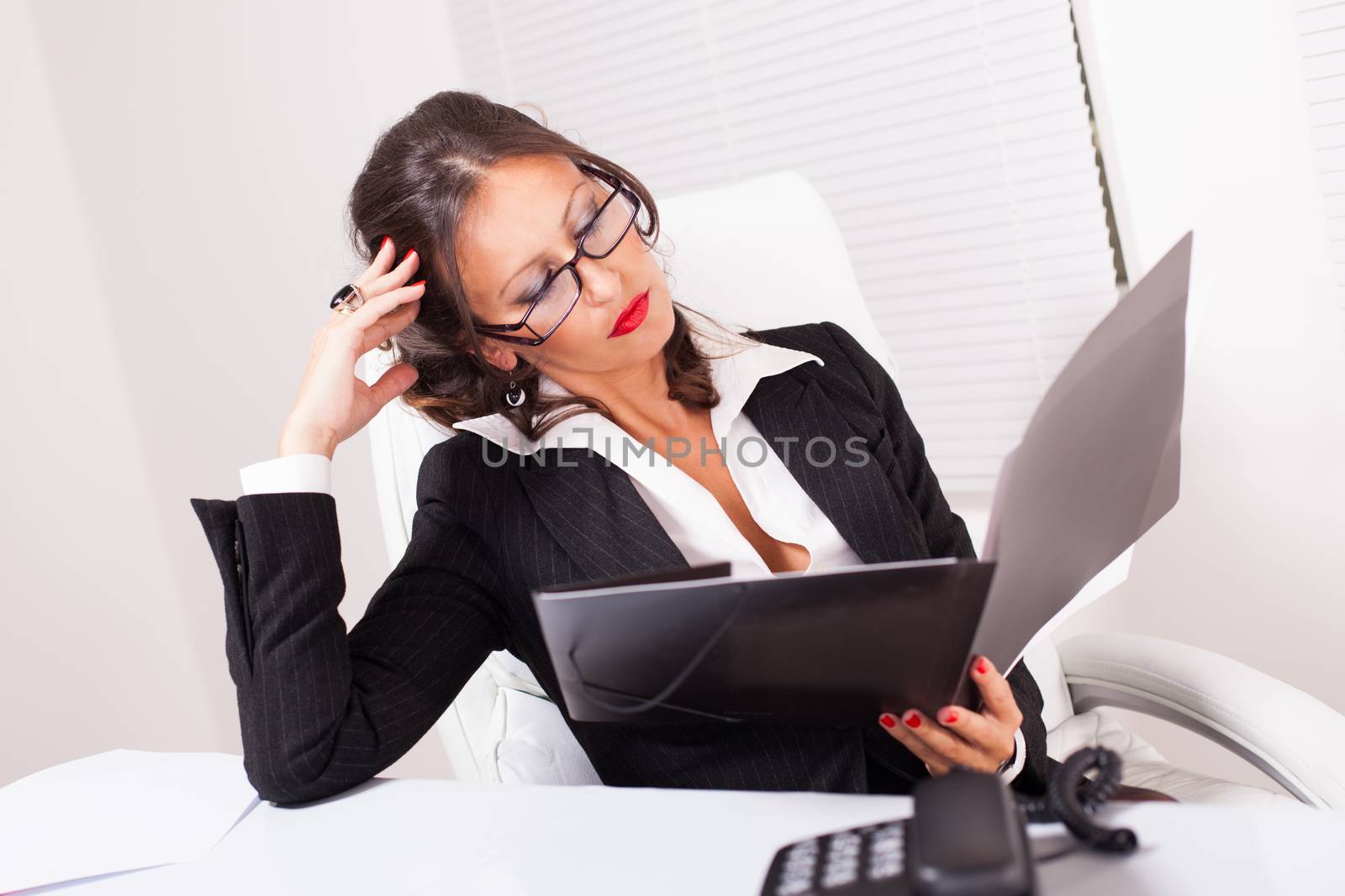 Beautiful attractive business woman with glasses reading business documents