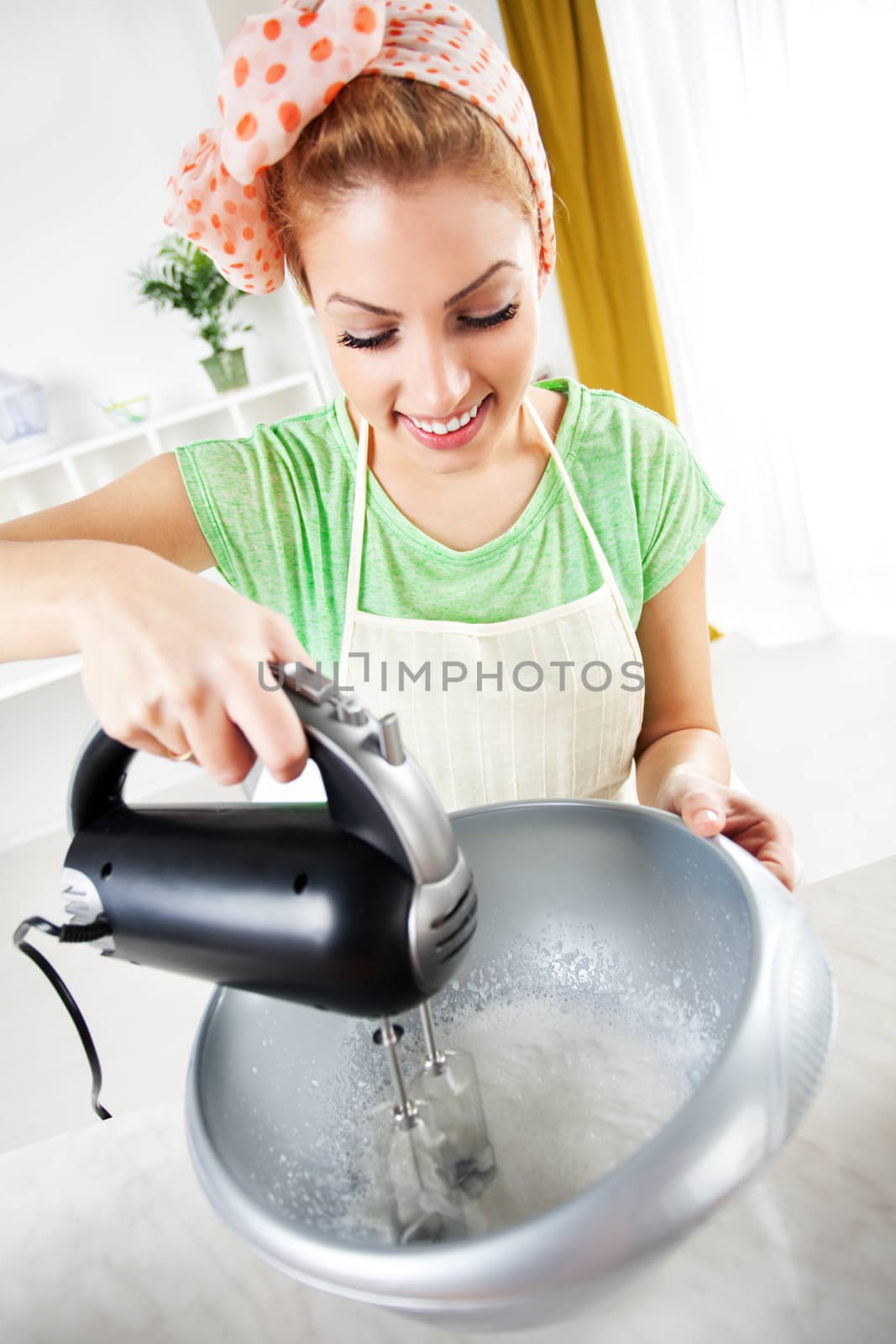 Beautiful young woman mixing of Whipped Cream in a kitchen. 