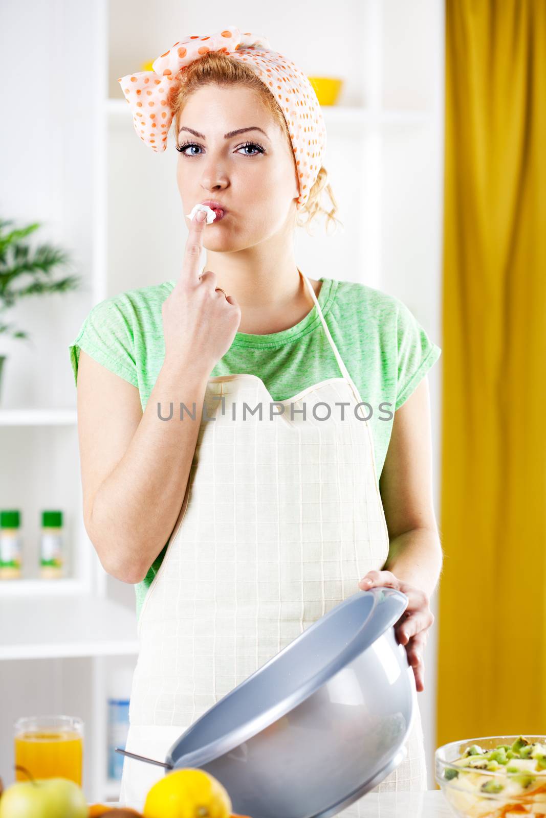 Beautiful young woman with Whipped Cream in a kitchen. Looking at camera.