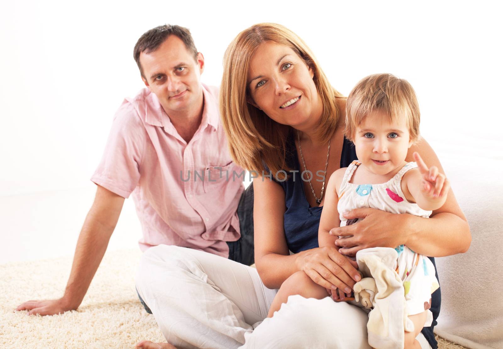 Beautiful happy family sitting on the floor and hugging each other