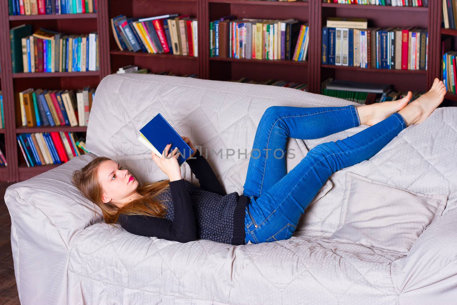 beautiful girl reading a book on sofa
