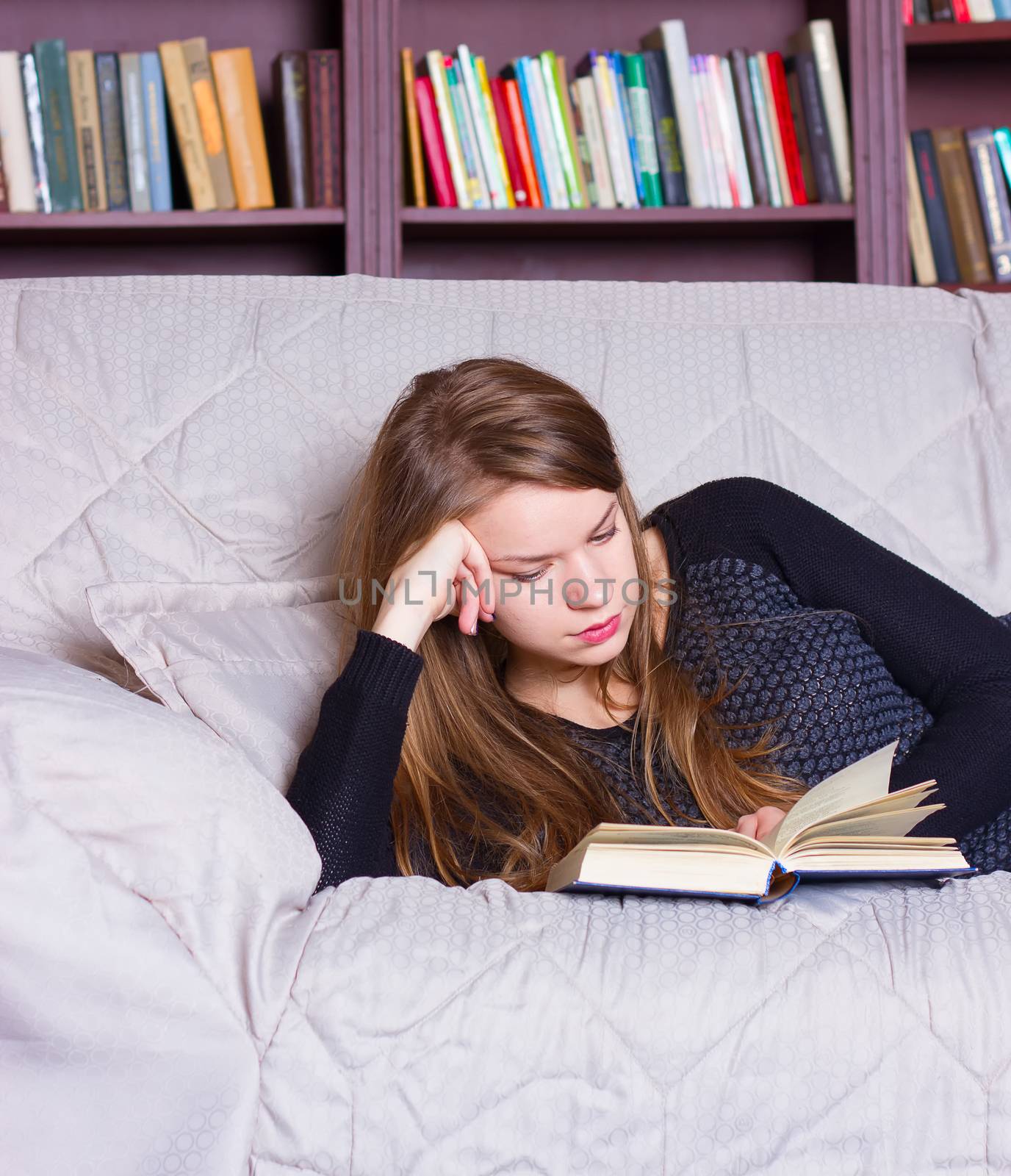 beautiful girl reading a book on sofa