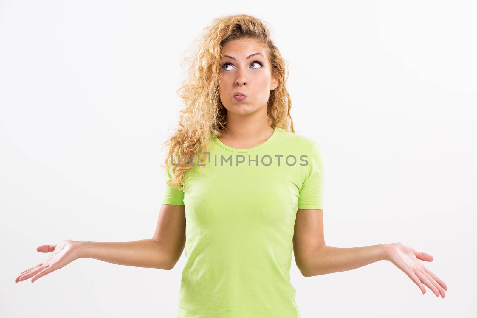 Portrait of beautiful pouty young woman thinking and spreads his arms. White background.