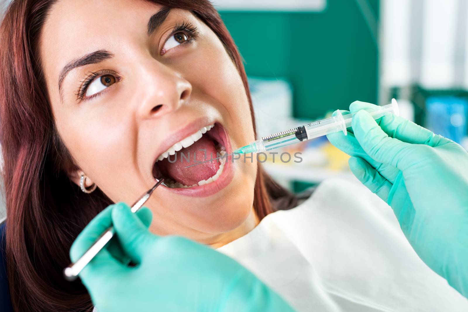 Dentist giving anesthesia to the patient before dental surgery. Selective focus, focus on the patient.