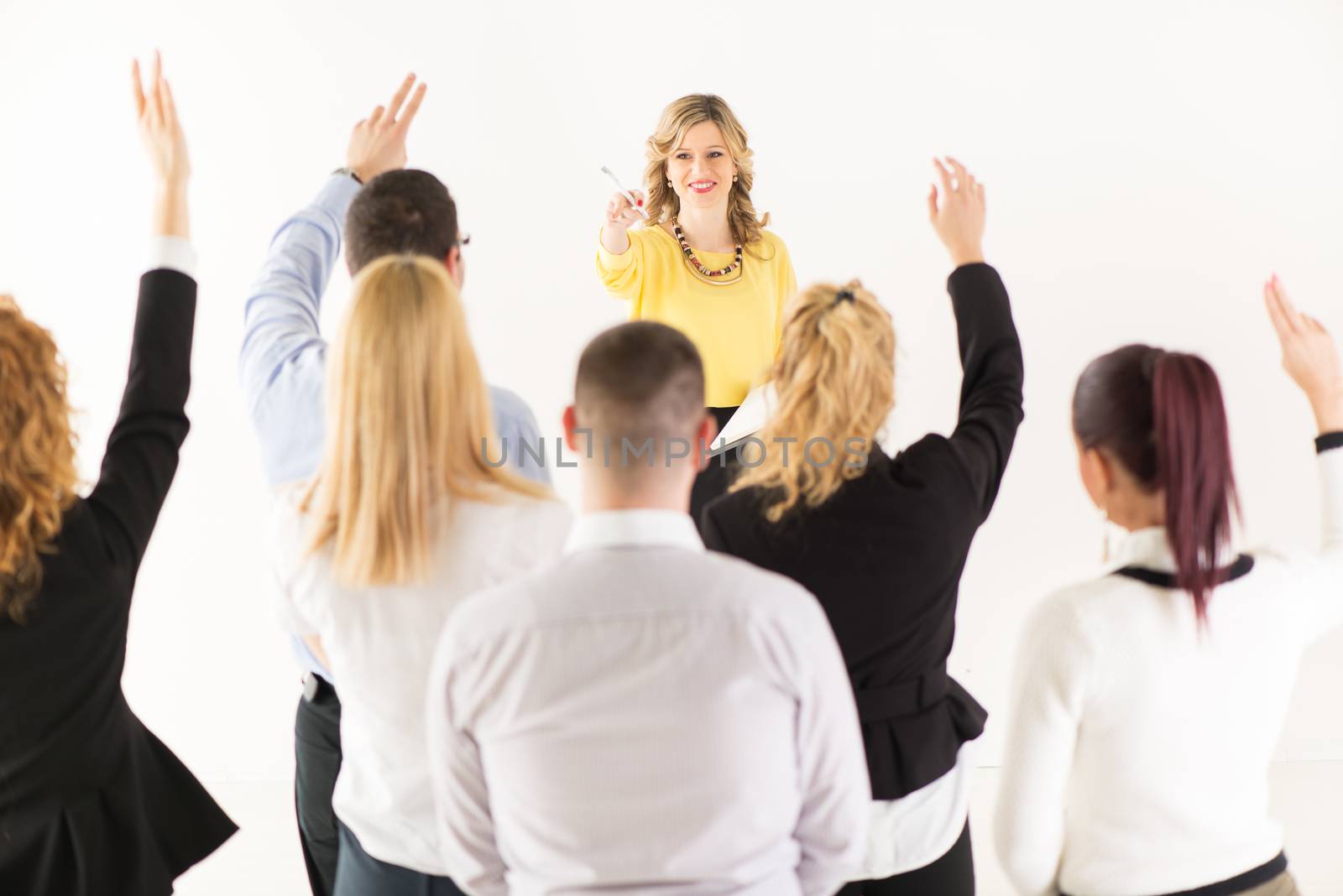 Friendly business woman explaining plan of work and answering the question. The team is listening and asking the questions.