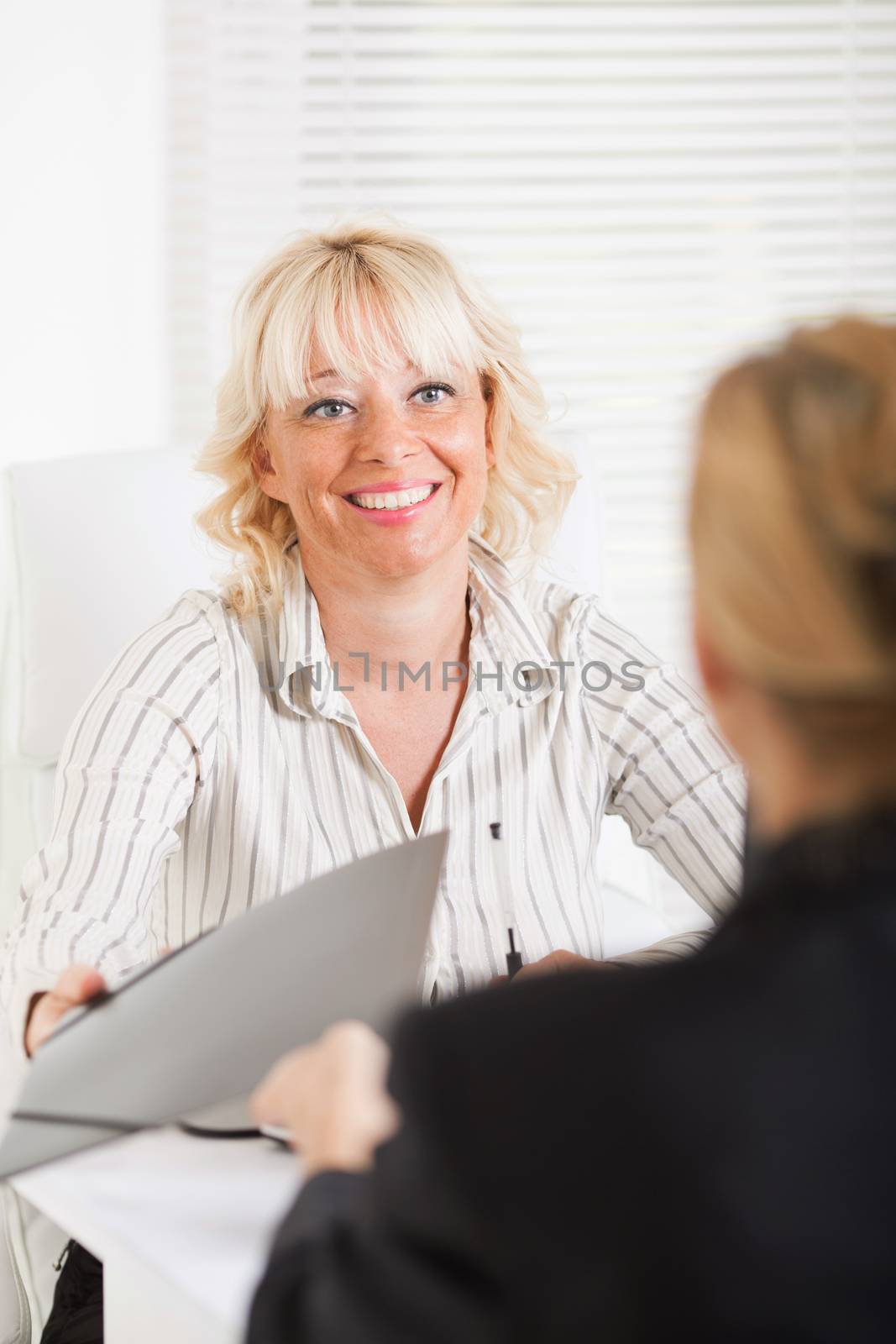 Friendly business women conducting deal in office 