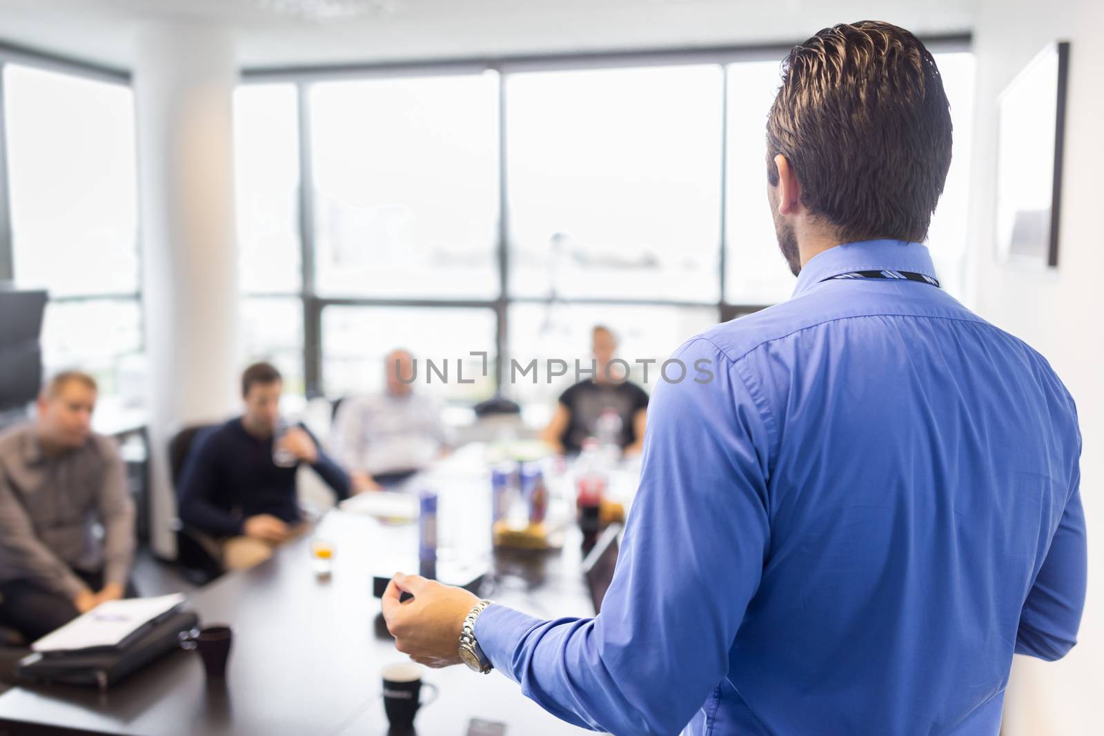 Business man making a presentation at office. Business executive delivering a presentation to his colleagues during meeting or in-house business training, explaining business plans to his employees. 