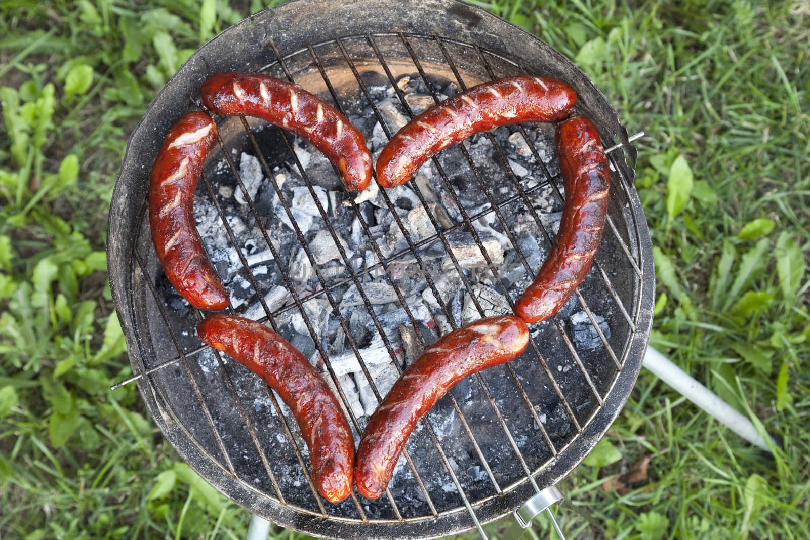 sausage on grill arranged in shape of heart 
