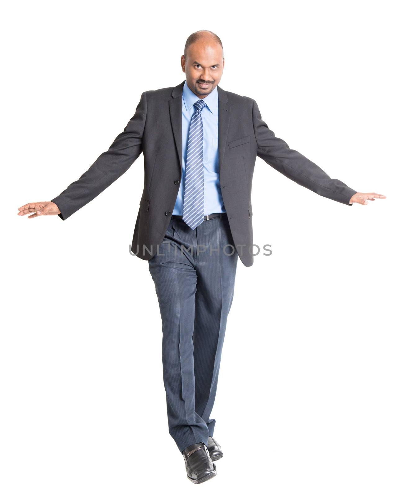 Full body Indian businessman walking balance , front view on plain background.