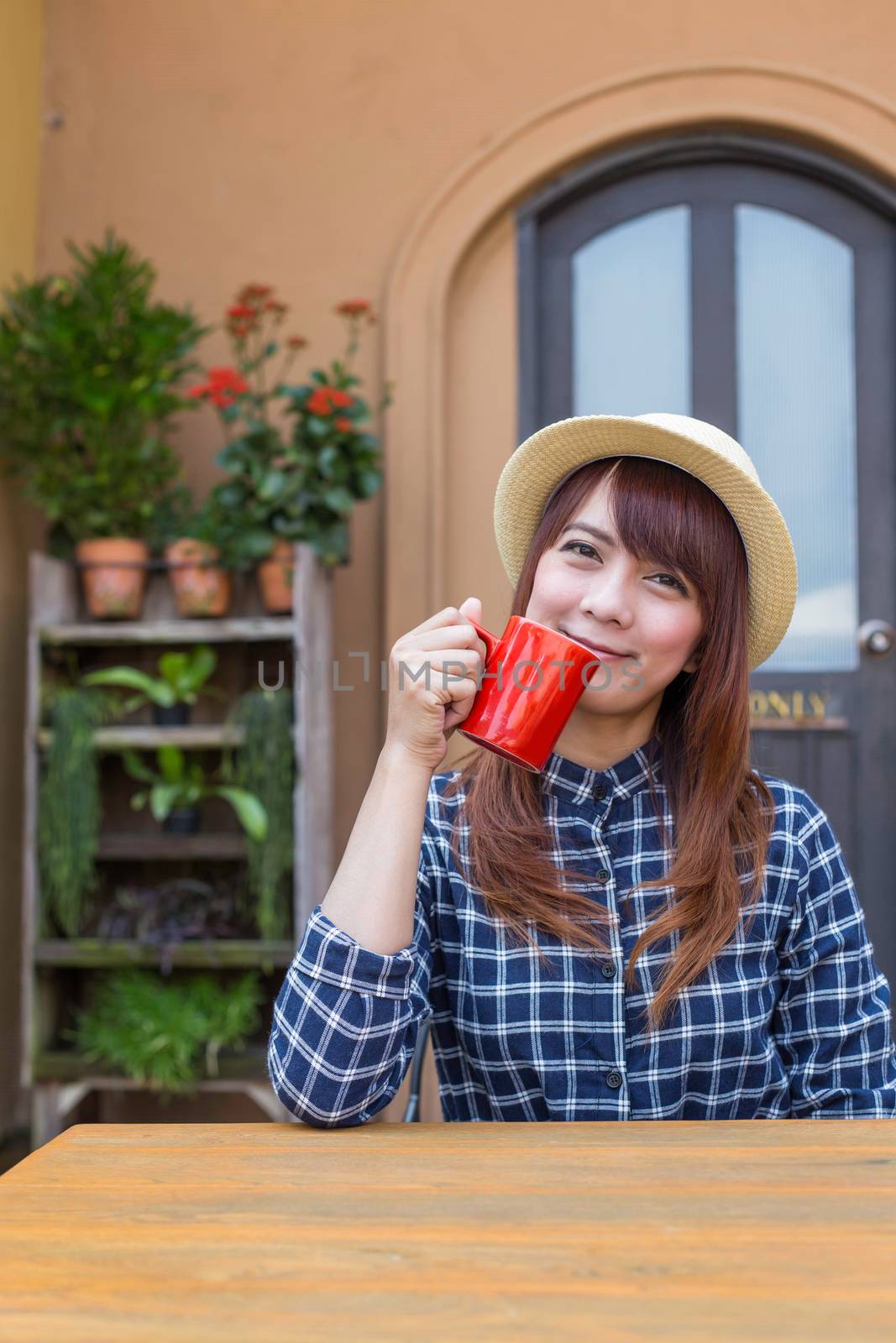 wear hat woman sitting in outdoor with warm drink relax