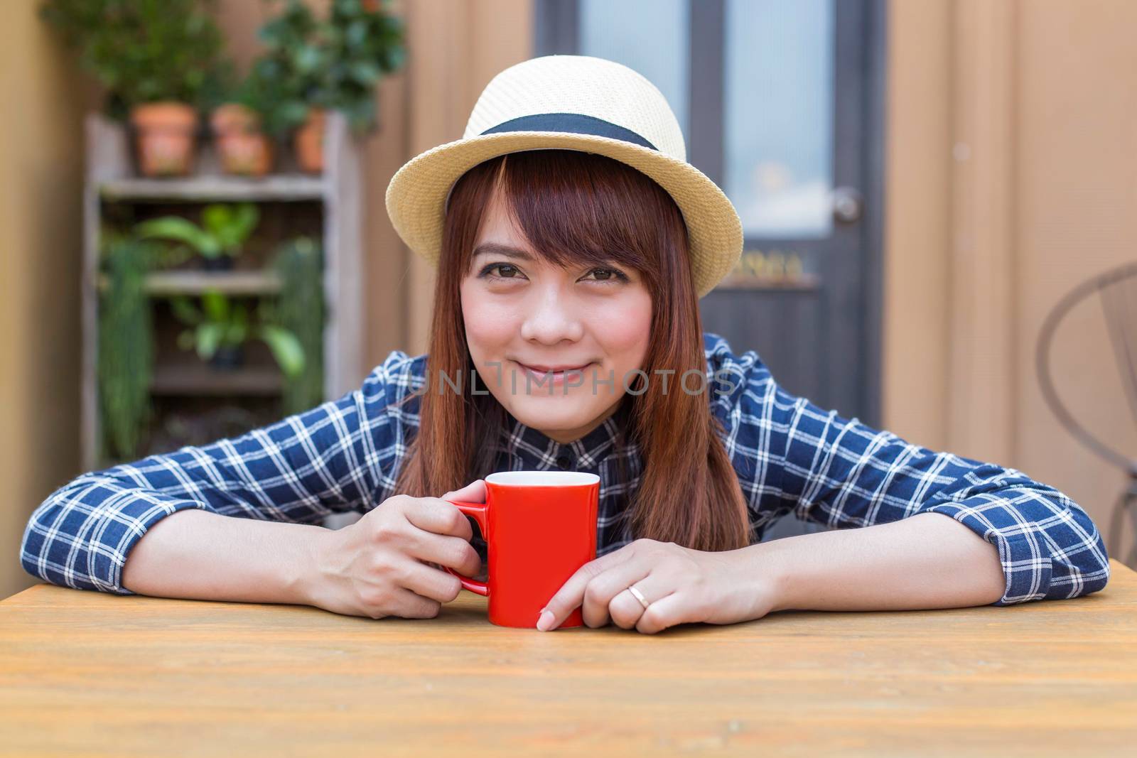 wear hat woman sitting in outdoor with warm drink relax