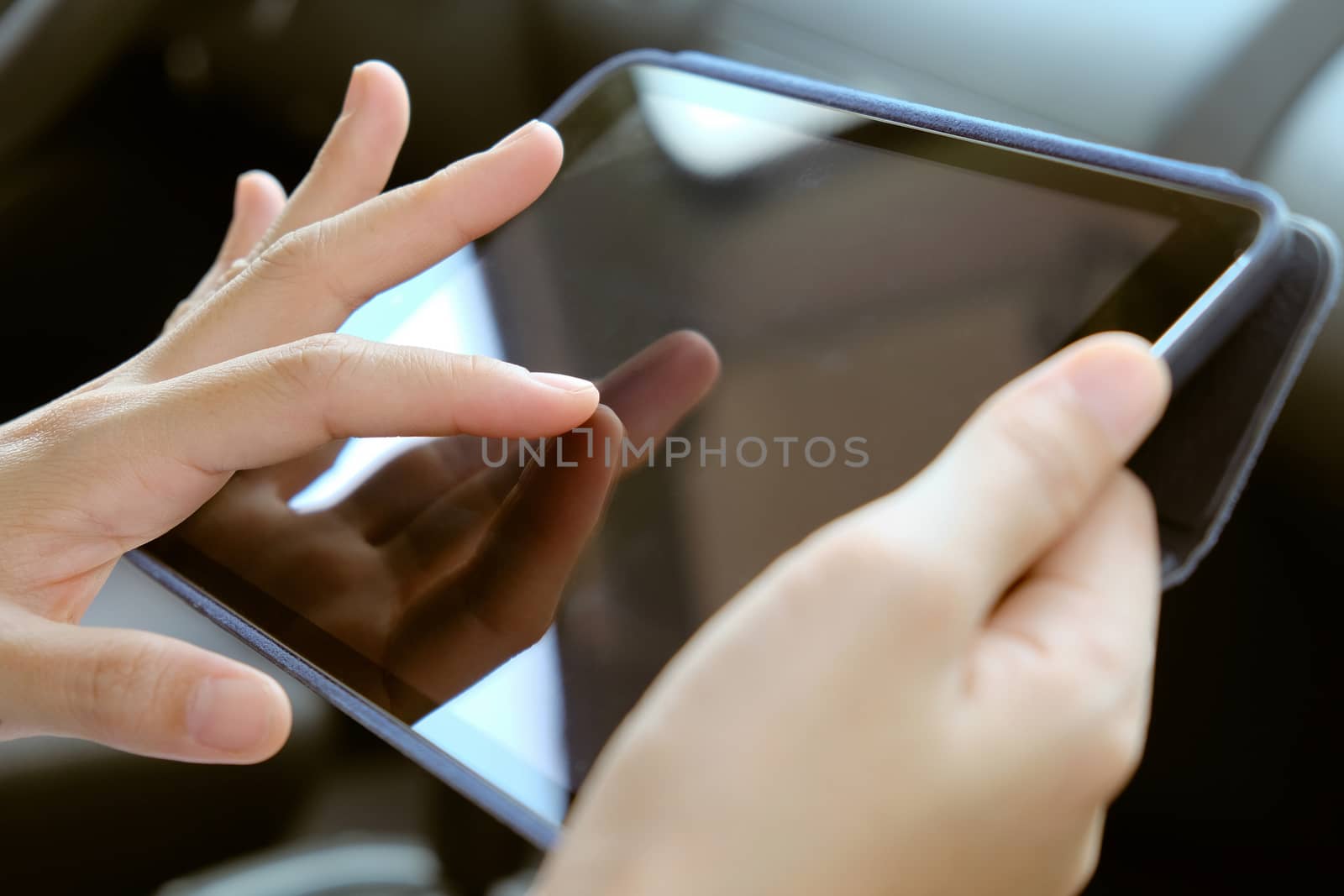 Woman Sitting in the Car and Using digital tablet.
