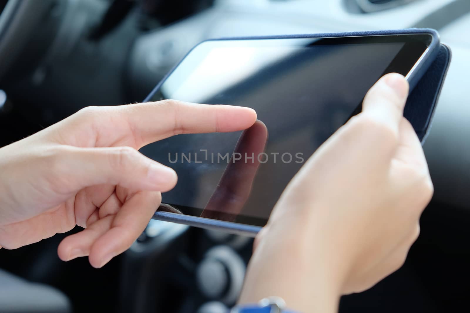 Woman Sitting in the Car and Using digital tablet.