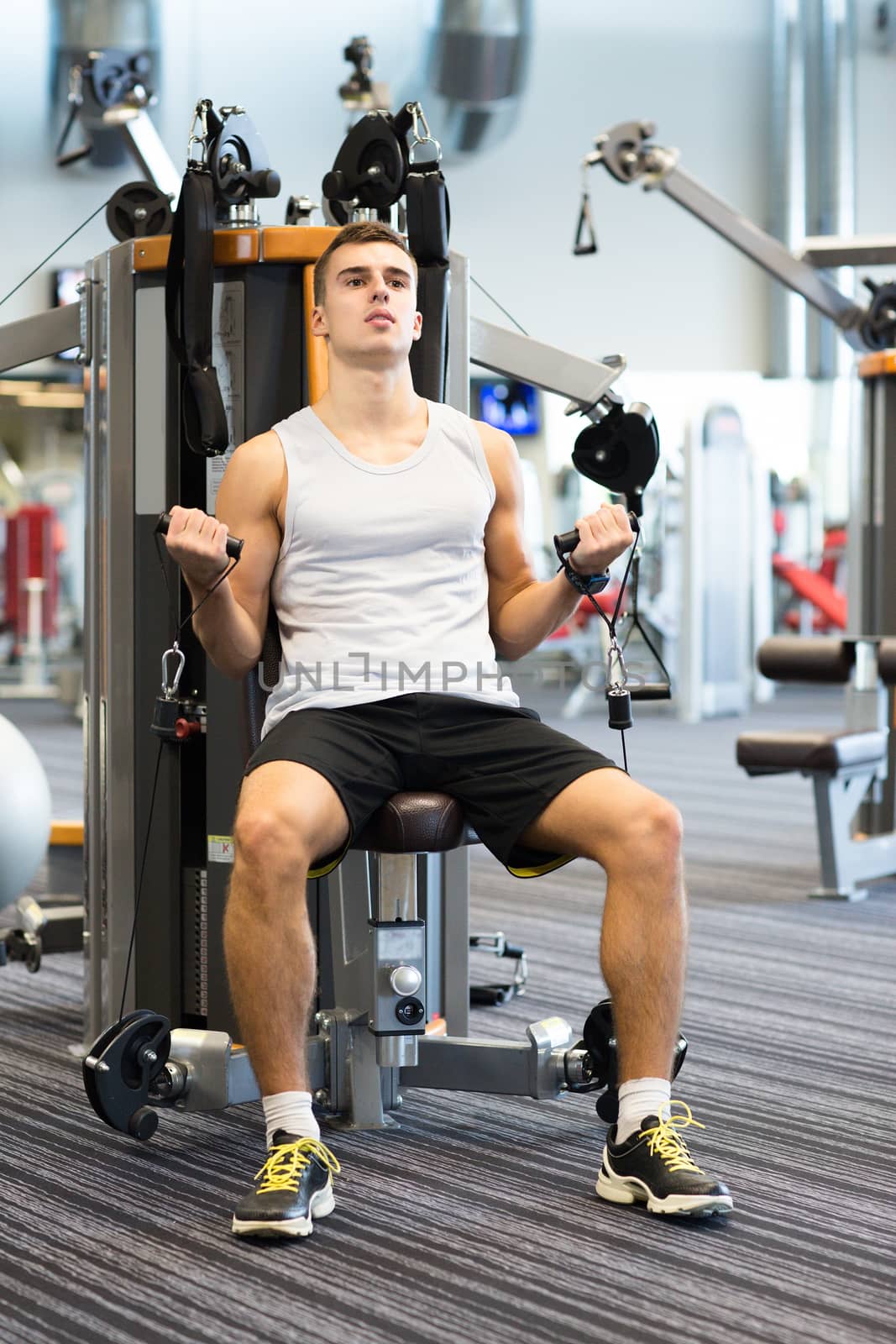 man exercising on gym machine by dolgachov