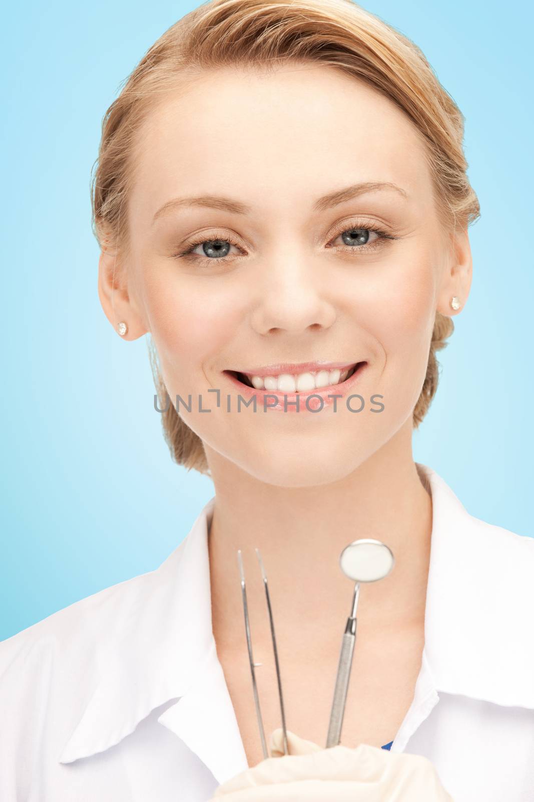 happy young female dentist with tools by dolgachov