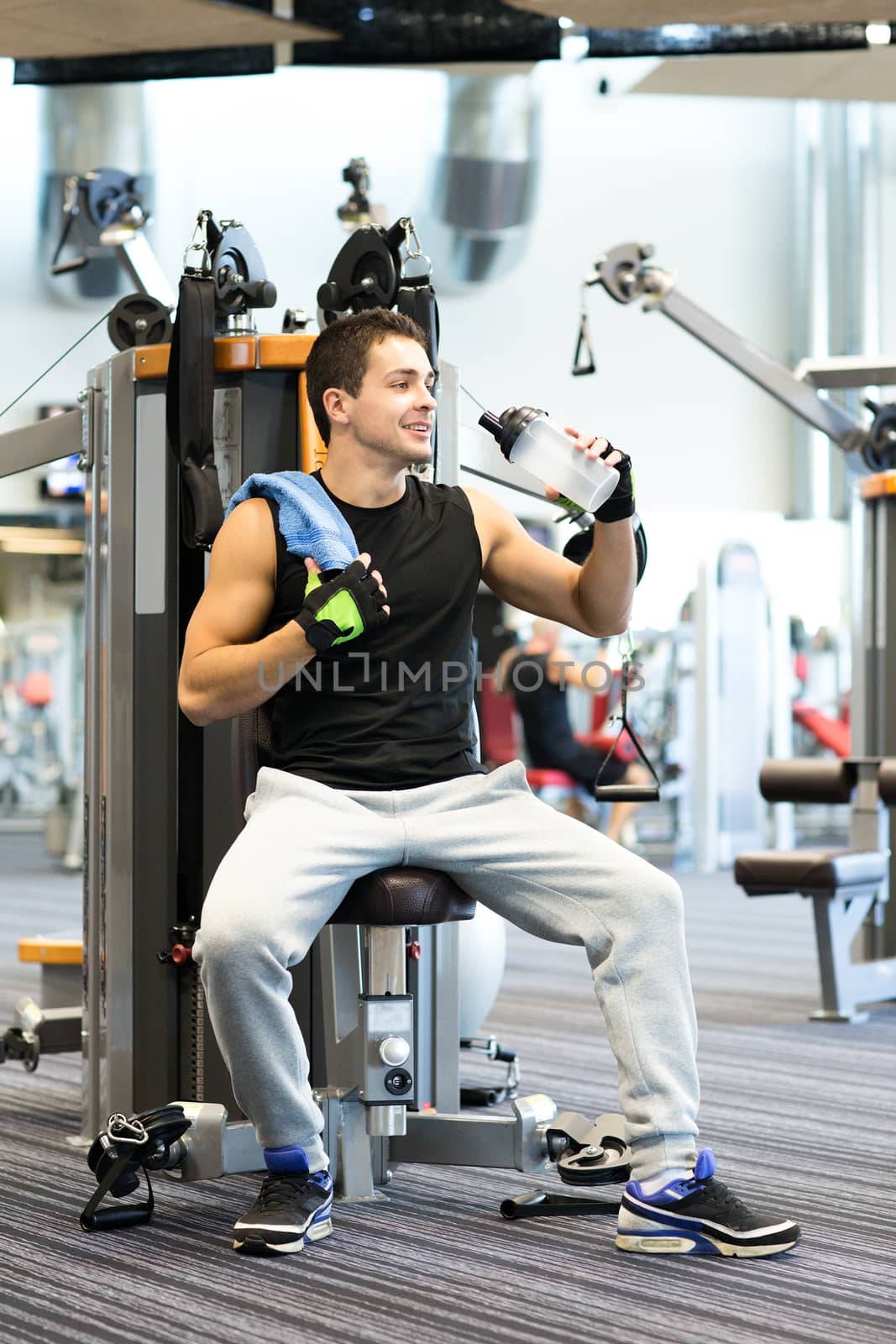 smiling man exercising on gym machine by dolgachov