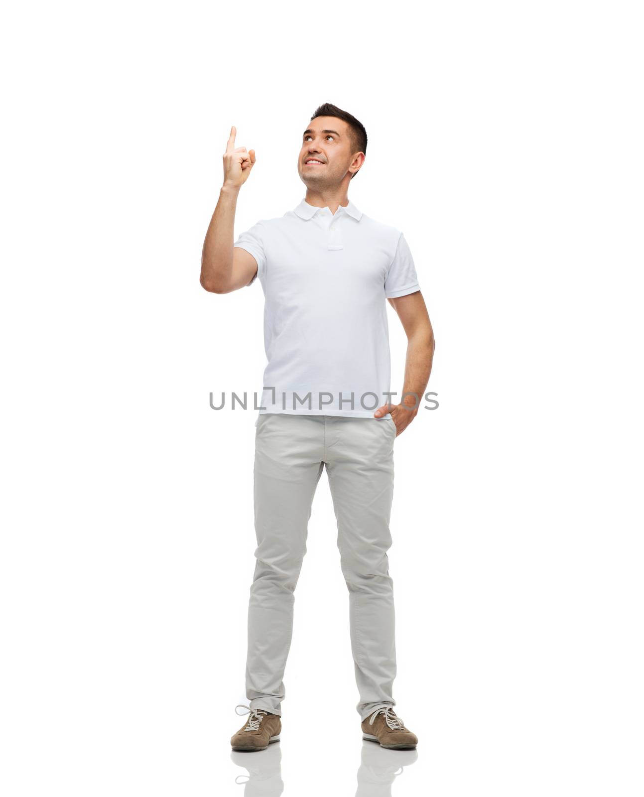 happiness, gesture and people concept - smiling man pointing finger up