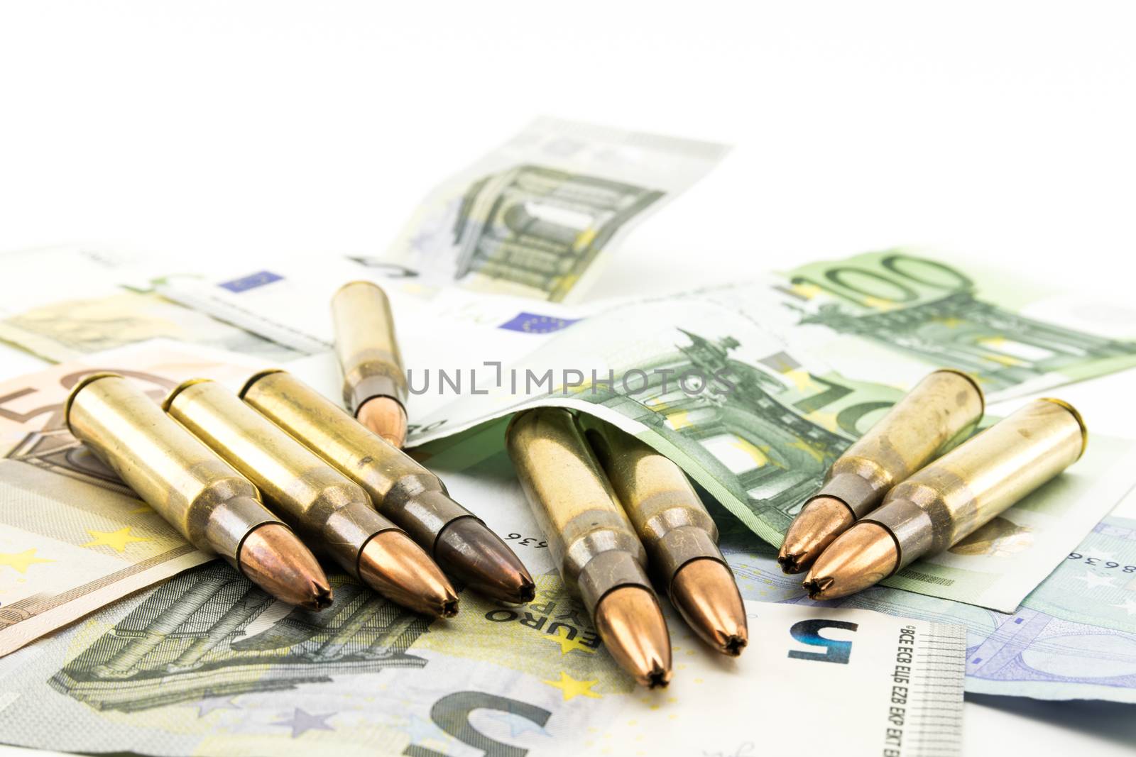 Composition with golden bullets and colorful banknotes.