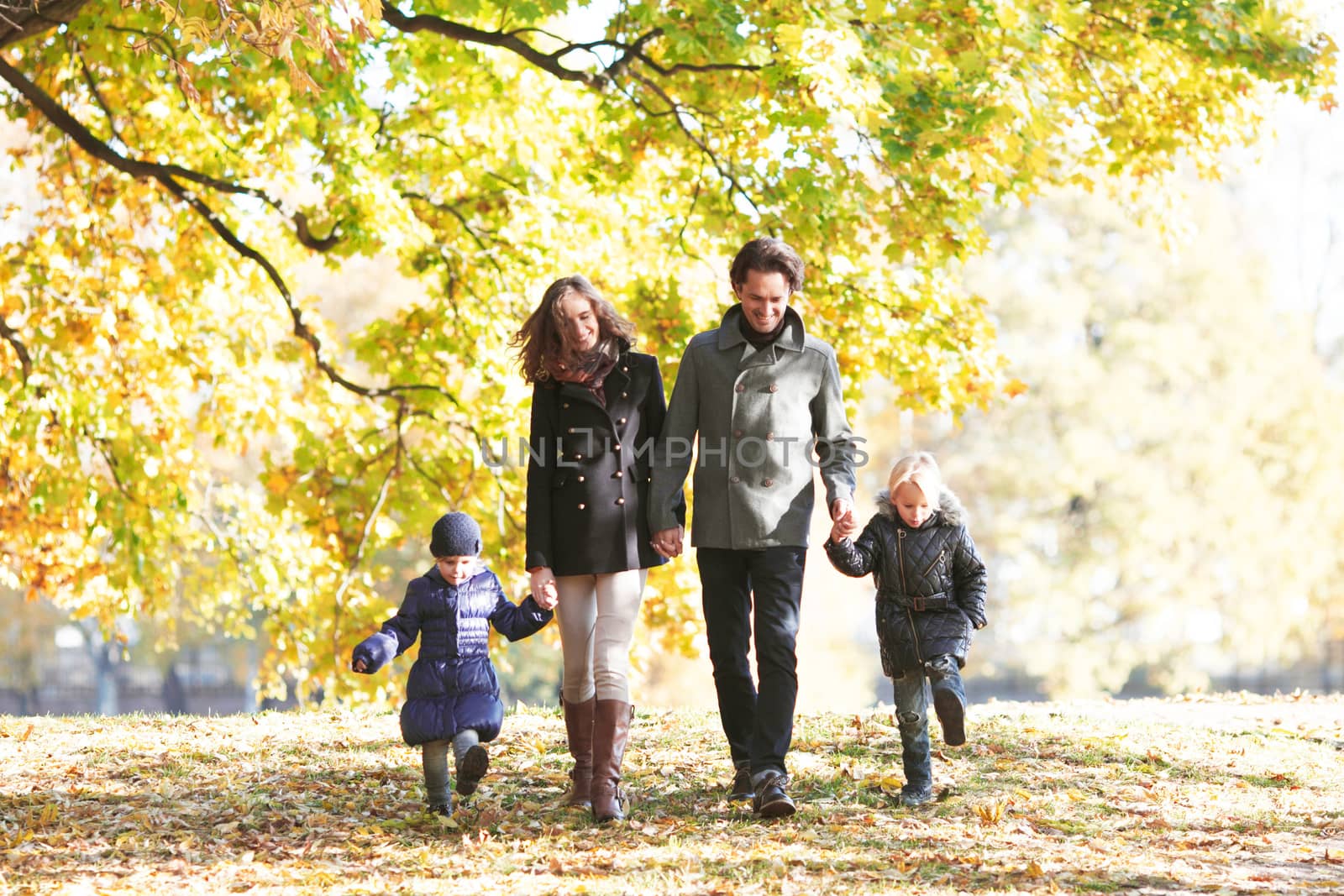 Portrait of family with children walking in autumn park