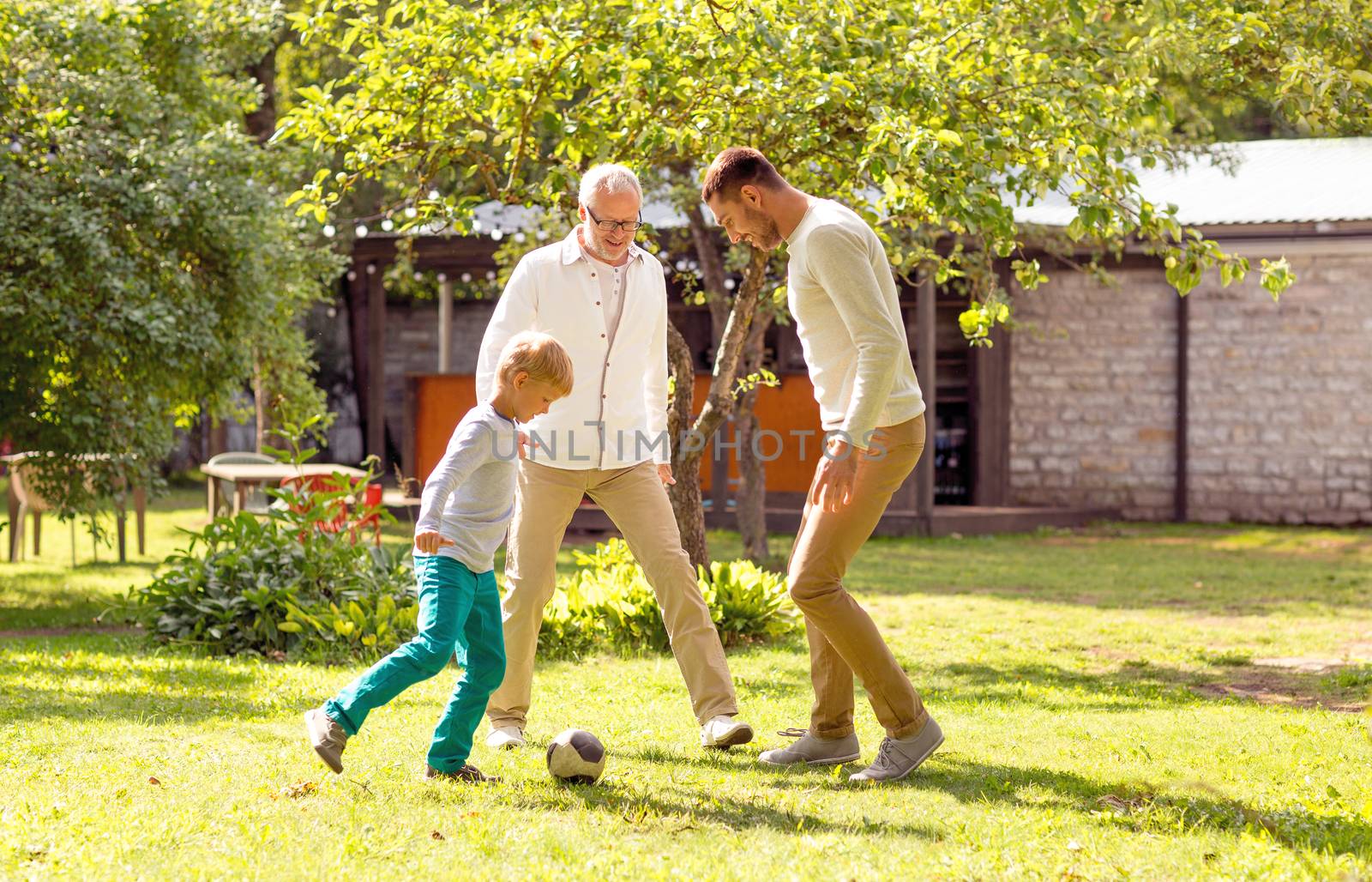 family, happiness, generation, home and people concept - happy family playing football in front of house outdoors