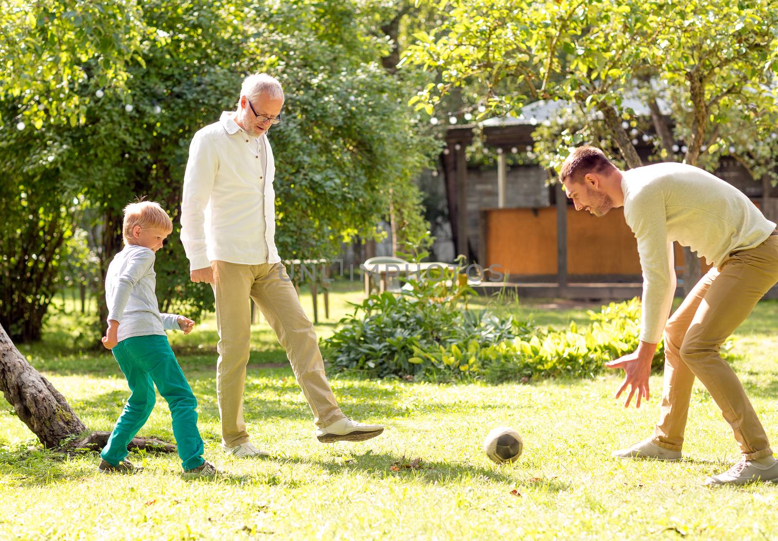 happy family playing football outdoors by dolgachov