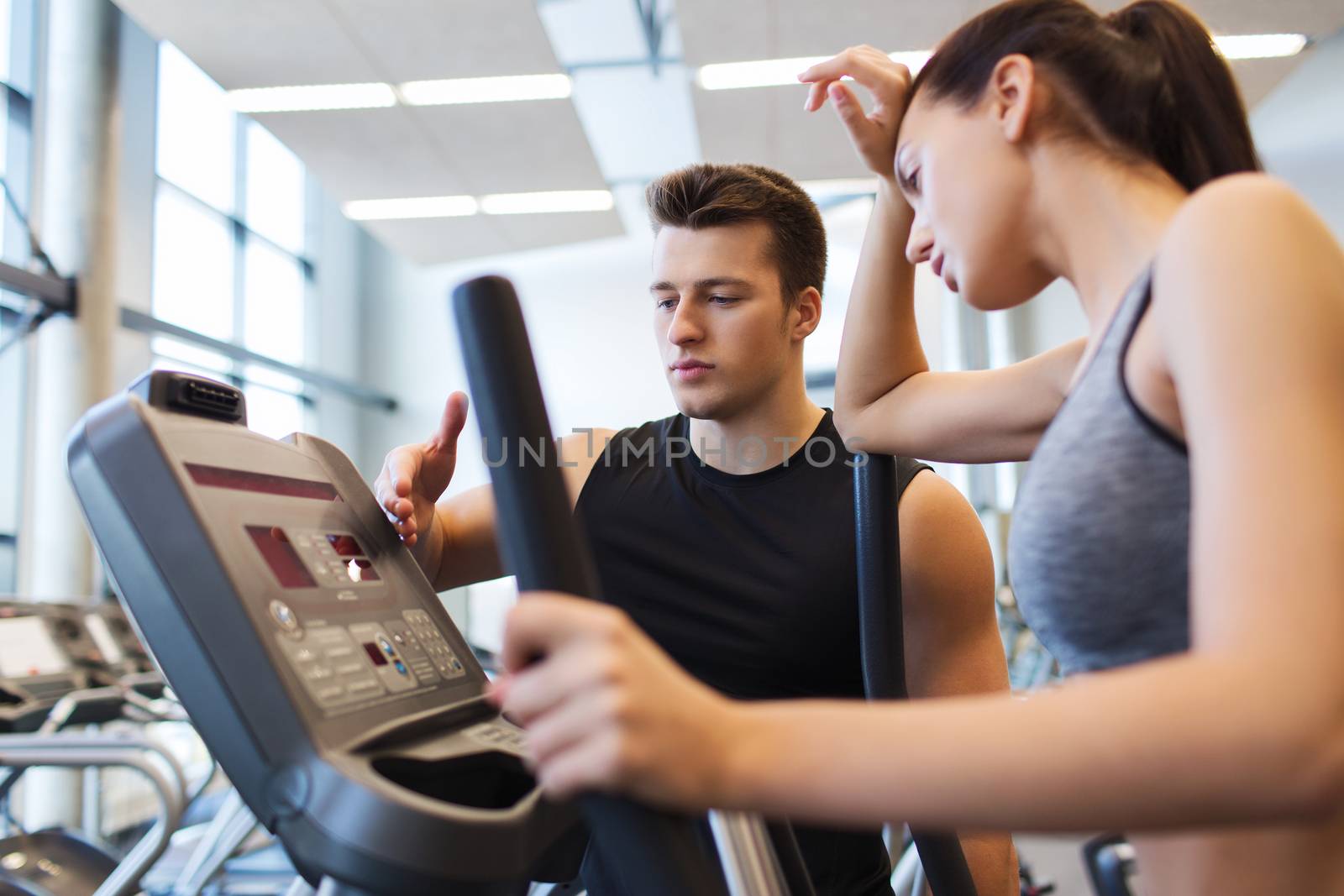 woman with trainer exercising on stepper in gym by dolgachov