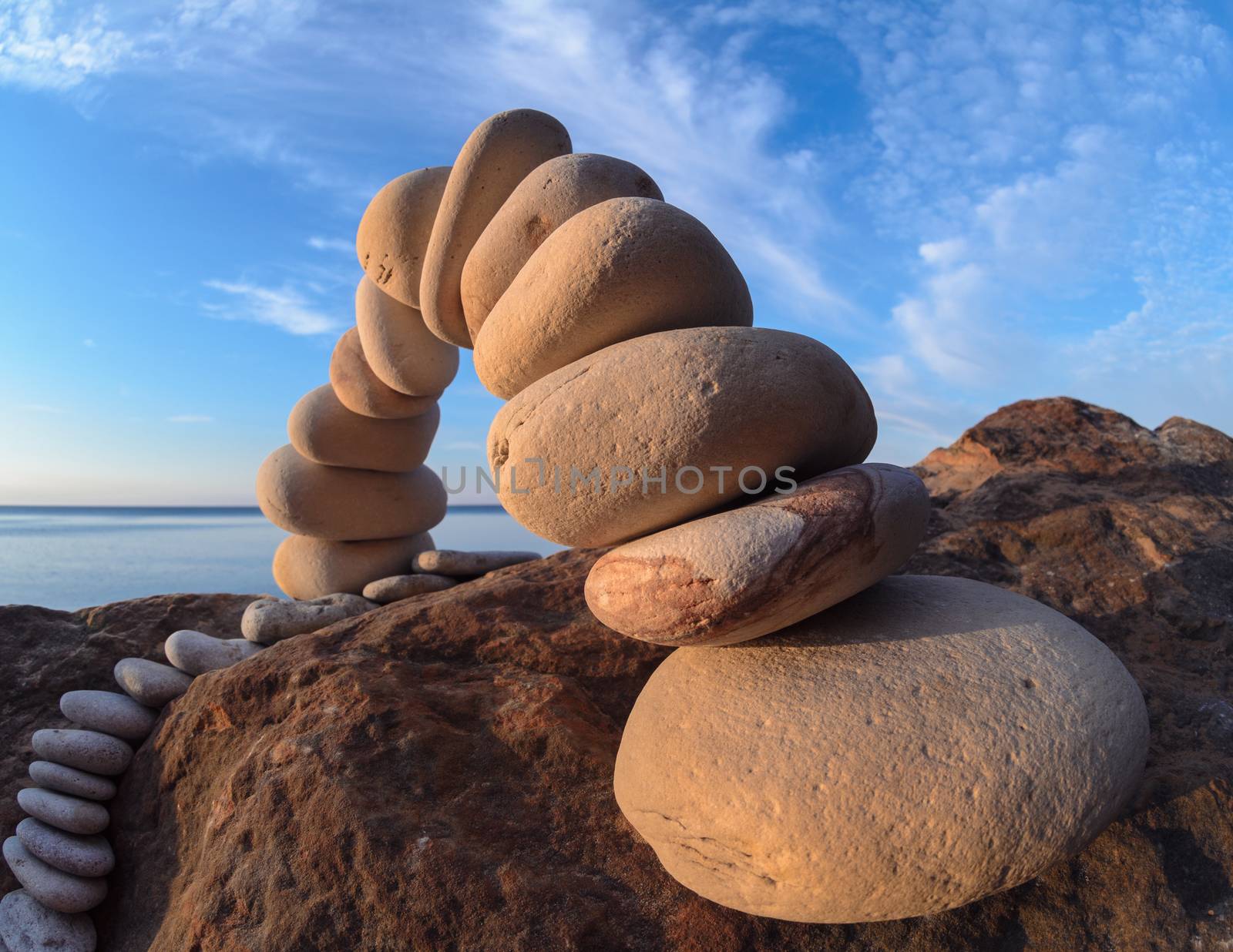 Curve of pebbles in the form of a arch on the coast