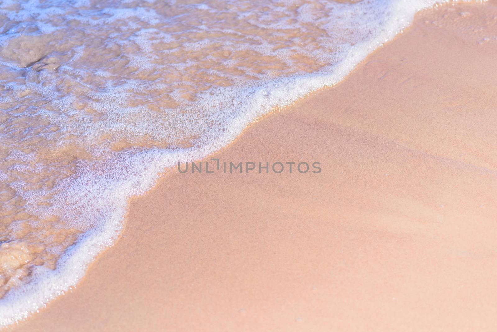 Transparent soft waves on the sandy beach